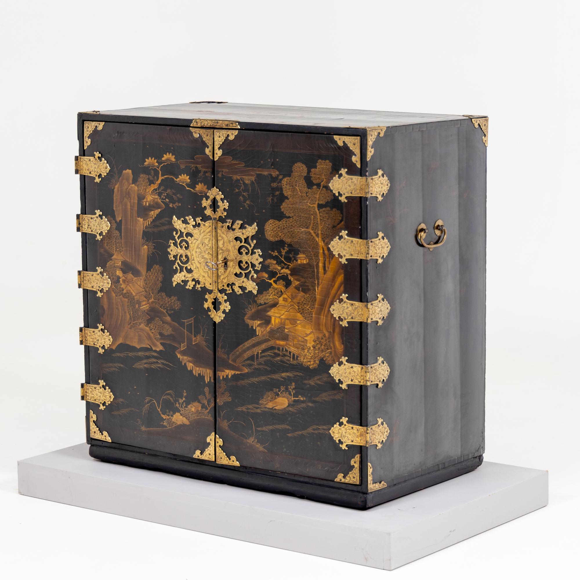 Two-door black lacquer cabinet made in Japan for the European market towards the end of the 17th century. The cabinet is decorated at the corners and in the centre as a key escutcheon with metal fittings of gilded copper with floral decoration. The