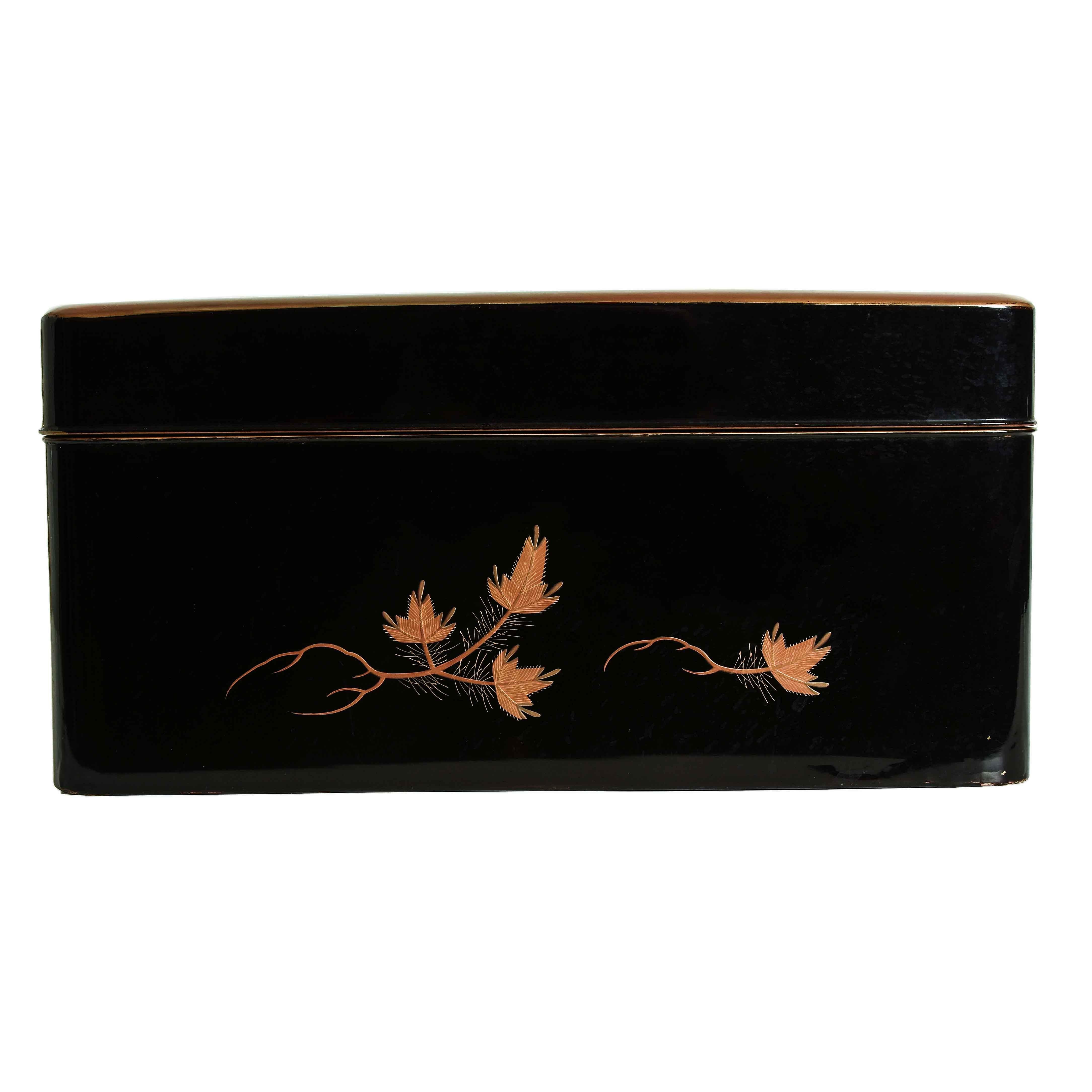 A Japanese black lacquer document box decorated with a motif of five flying cranes over a landscape with conifers, grasses and a rushing brook, all exquisitely rendered in gold, silver and bronze maki e. The conifer motif is carried around the sides