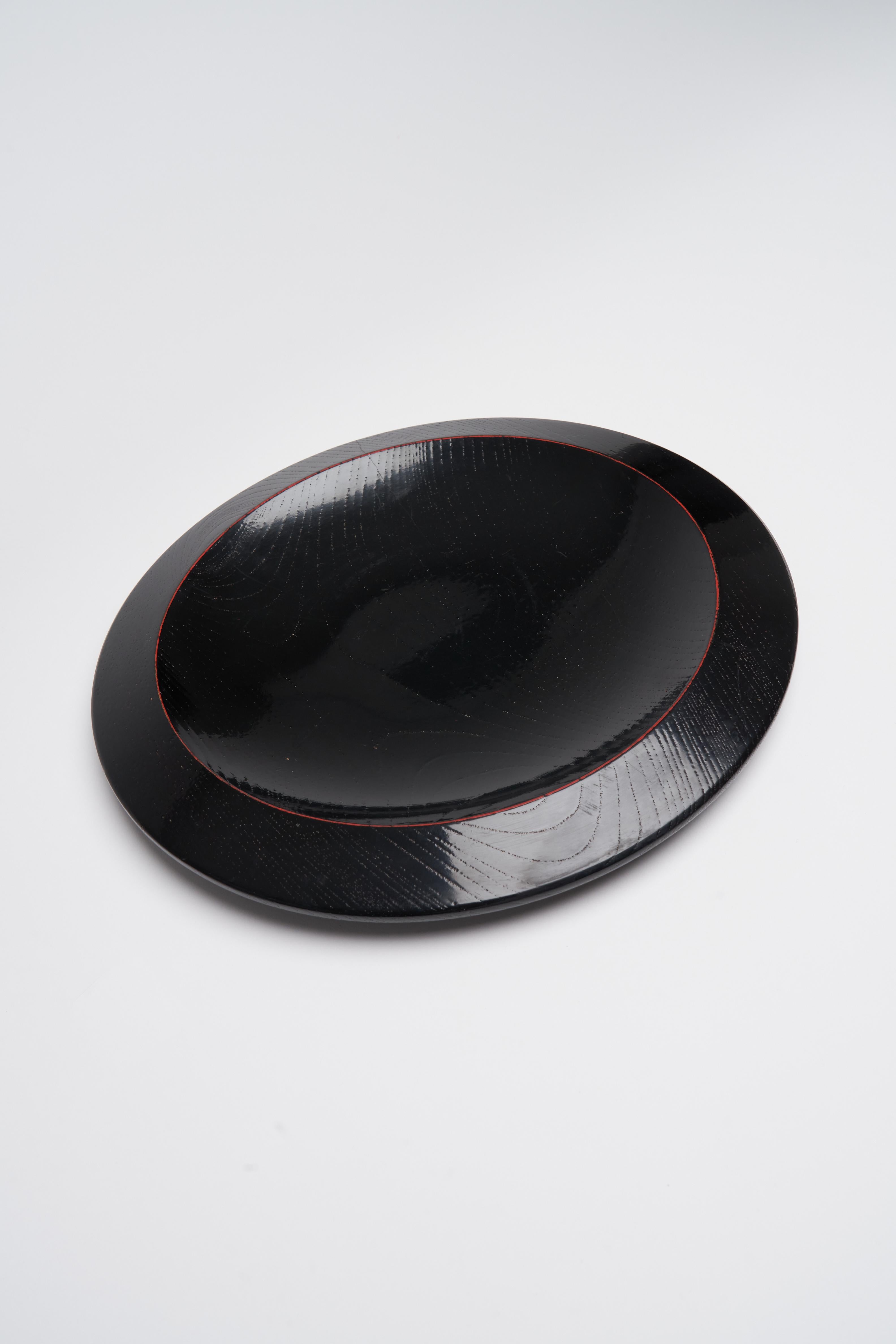 This stunning wooden tray adorned with the classic Japanese Lacquer shines back at you - almost to mirror your every desire. You must see yourself in this plate. Concave and convex. Shaped with shapes that defy your own logic of what a plate can be.