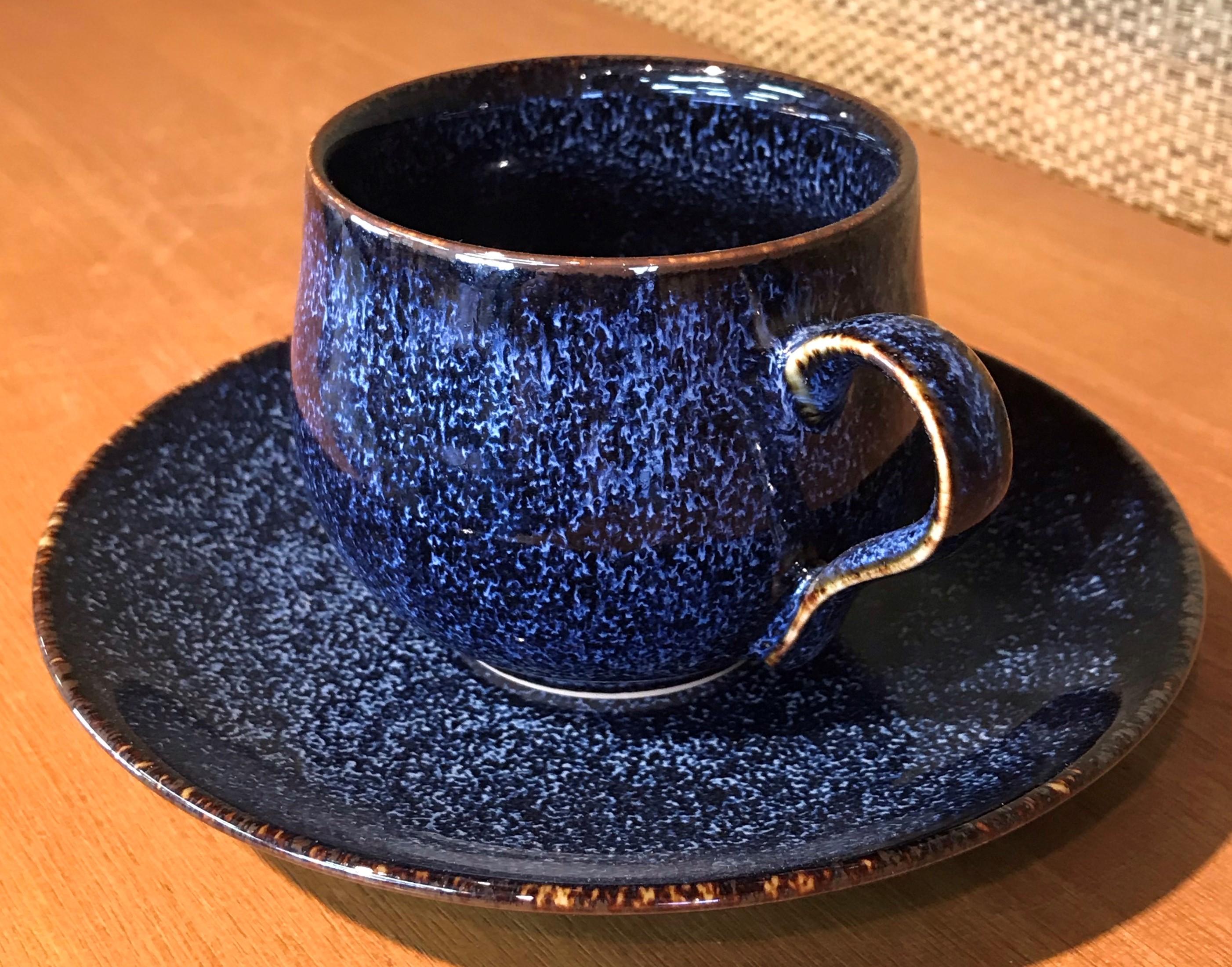 Contemporary Japanese porcelain cup and saucer, hand-glazed in mesmerizing signature blue and black, a signed work by highly acclaimed award-winning master porcelain artist from the Imari-Arita region of Japan. 

In this extraordinary piece, the