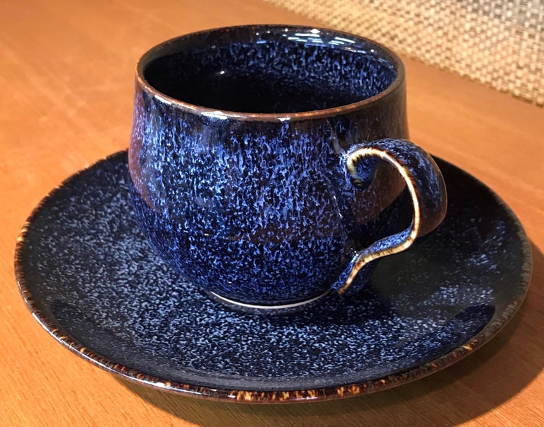 Contemporary Japanese porcelain cup and saucer, hand-glazed in mesmerizing signature blue and black, a signed work by highly acclaimed award-winning master porcelain artist from the Imari-Arita region of Japan. 

In this extraordinary piece, the