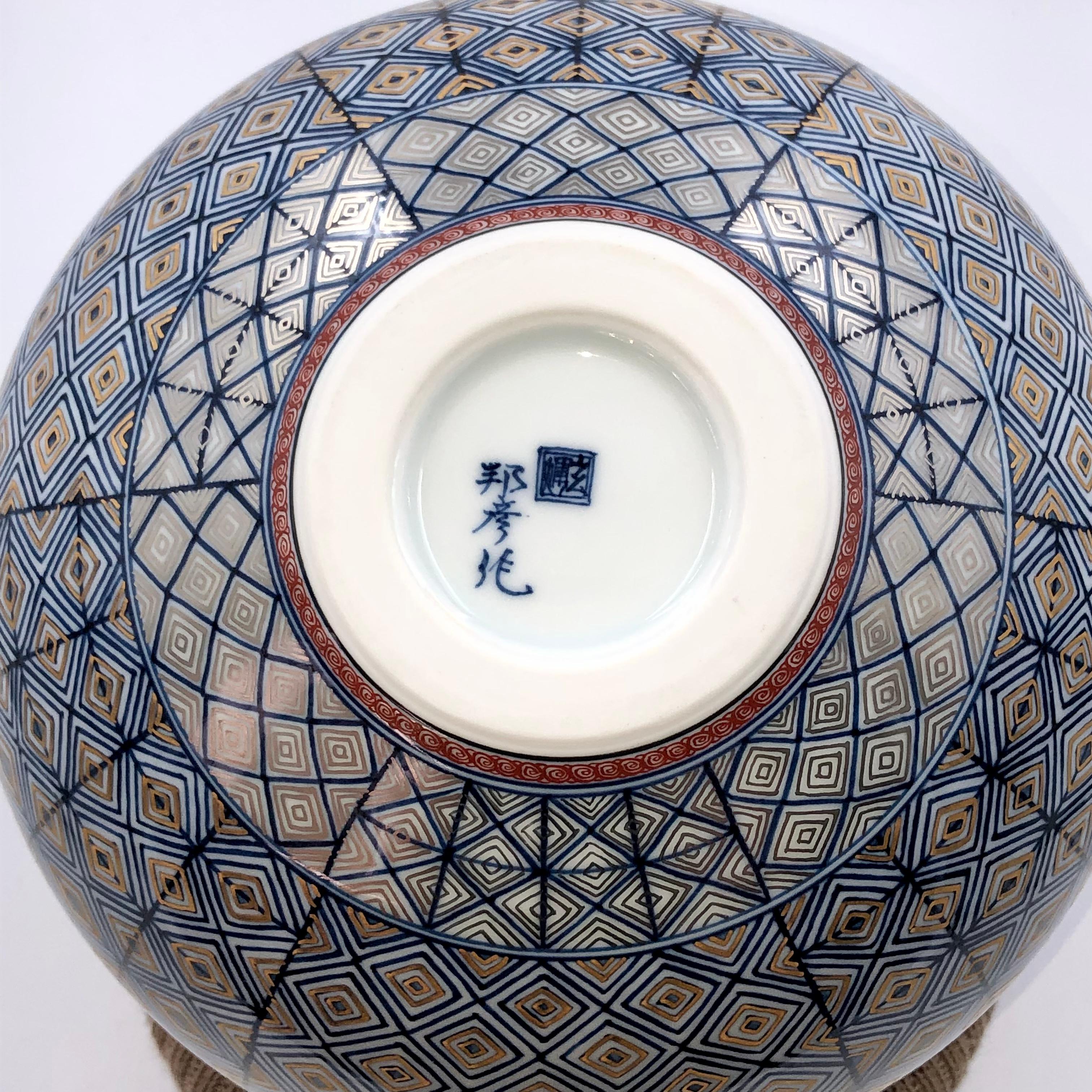 Exquisite Japanese contemporary museum quality decorative porcelain vase in a stunning ovoid shape featuring the artist's signature geometric pattern that is extremely intricately hand painted in stunning deep blue and gold. It is a signed