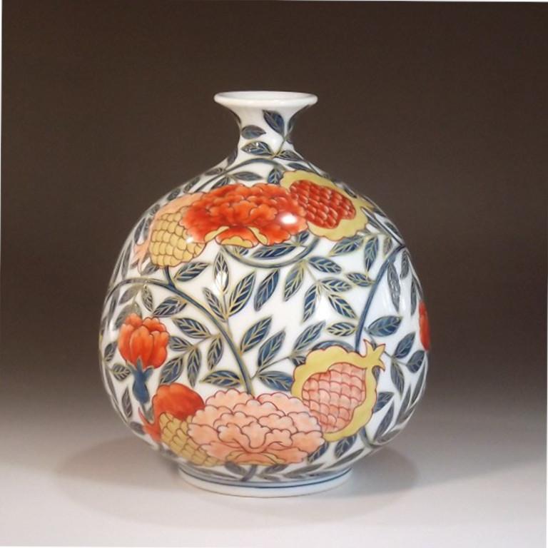 Exquisite contemporary Japanese porcelain decorative vase hand painted in red, pink and blue on an elegantly shaped body, a signed work by highly acclaimed Japanese master porcelain artist in Imari-Arita tradition of Japan, and recipient of numerous