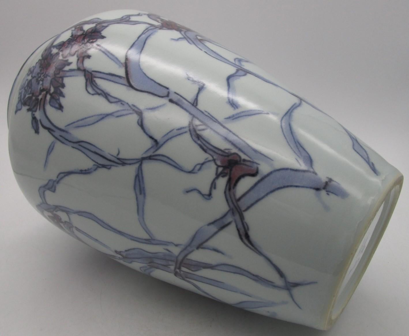Vase en porcelaine décoratif japonais du milieu du XXe siècle signé (vers 1935,) de la période Showa (1926 à 1985). Il représente un joli motif de carthame, une scène élégante peinte à la main en violet et bleu sous glaçure sur un fond blanc pur,