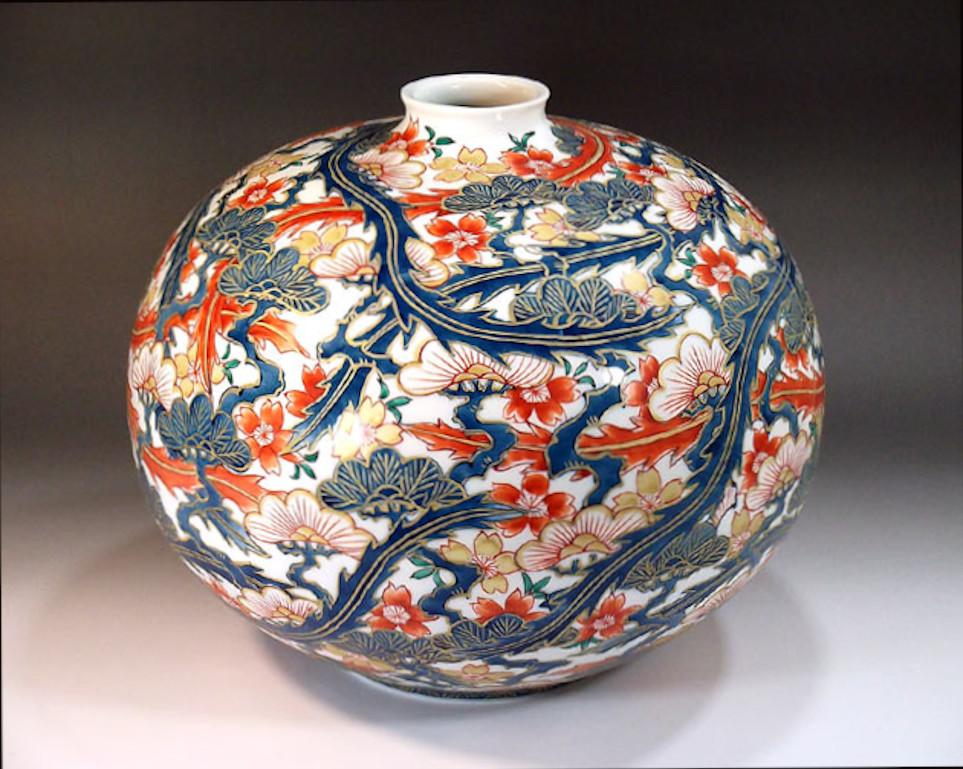 Exquis vase contemporain en porcelaine décorative japonaise, doré et peint à la main dans des tons de rouge, de bleu et d'or sur un corps globulaire saisissant. Il s'agit d'une œuvre signée par un maître artiste de la porcelaine de la région