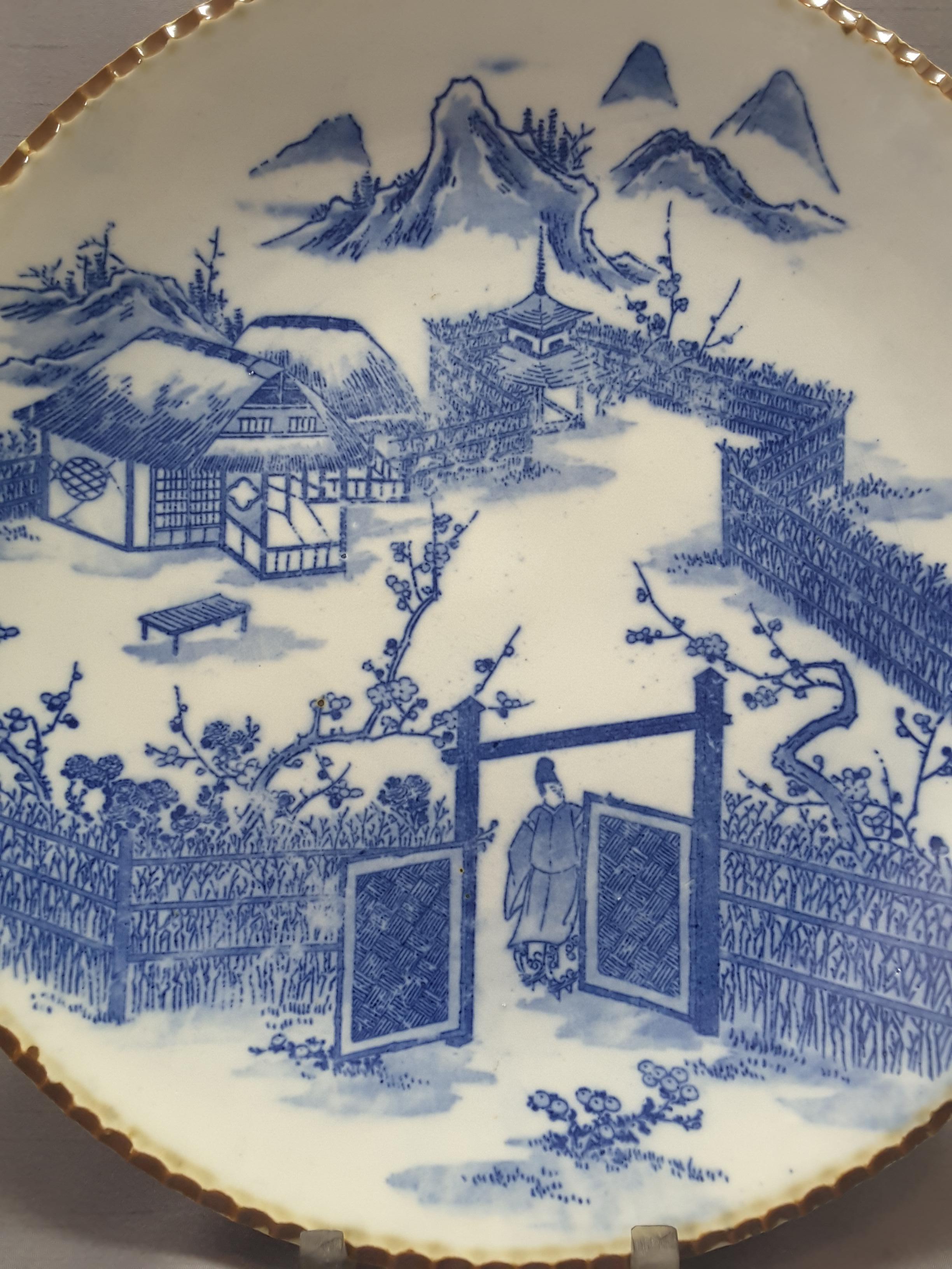 Japanese Blue & White Charger, Compound/Home Scene, Late 19th/Early 20th Century. Scalloped edge with rust brown detail, bright blue on white decoration.The back has double blue ring detail, spur firing from kiln, three scene decoration on back rim.