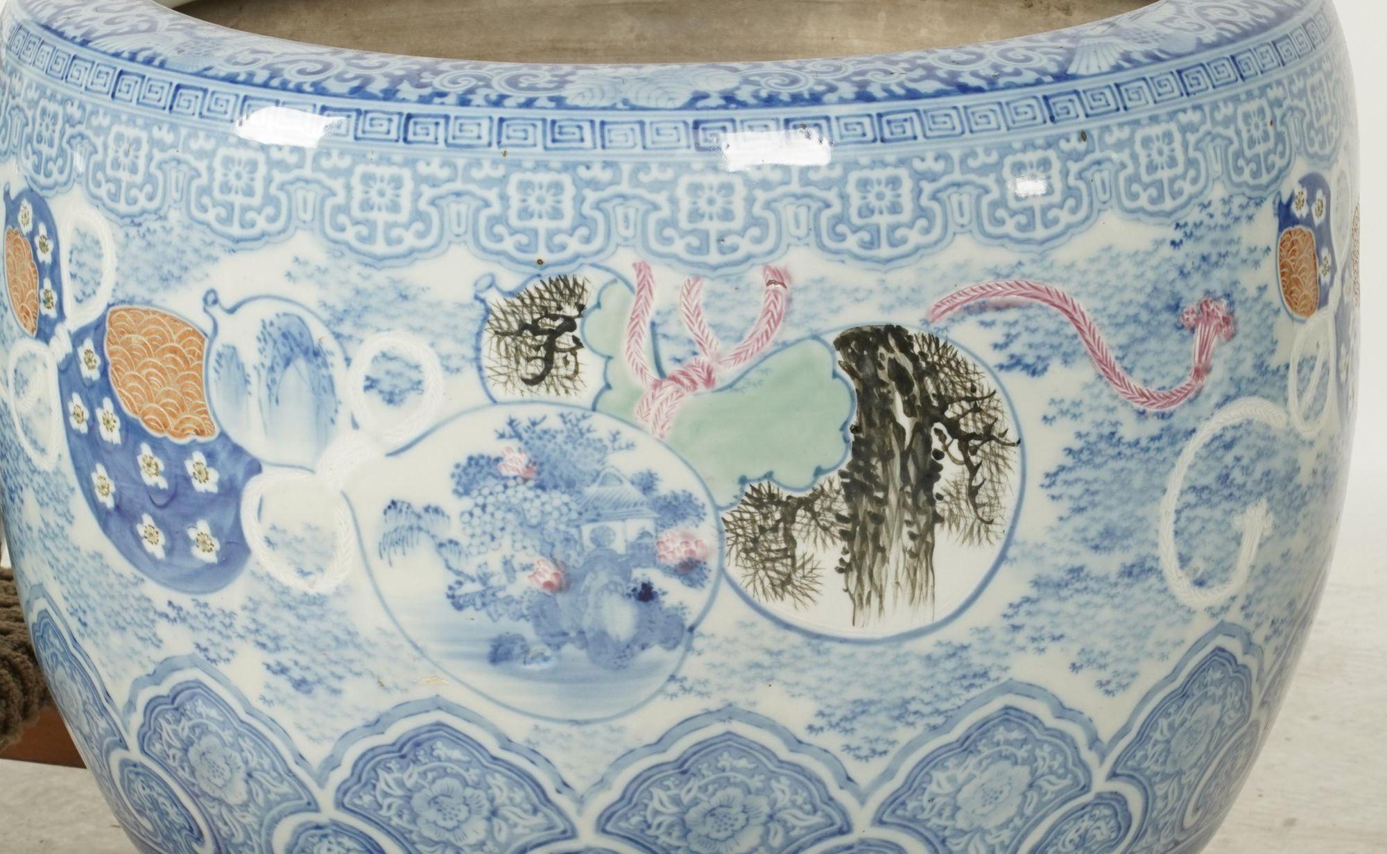 Early 20th-century Japanese hibachi crafted in blue-and-white porcelain, decorated with intricate hand-painted patterns encircling a continuous trail of double gourds—auspicious symbols of health, longevity, and good fortune. Several gourds contain