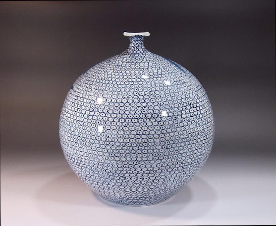 Exquis vase décoratif en porcelaine japonaise contemporaine, peint à la main de manière extrêmement complexe en bleu cobalt sous glaçure sur un corps en porcelaine globulaire aux formes élégantes, une pièce signée par un maître artiste porcelainier