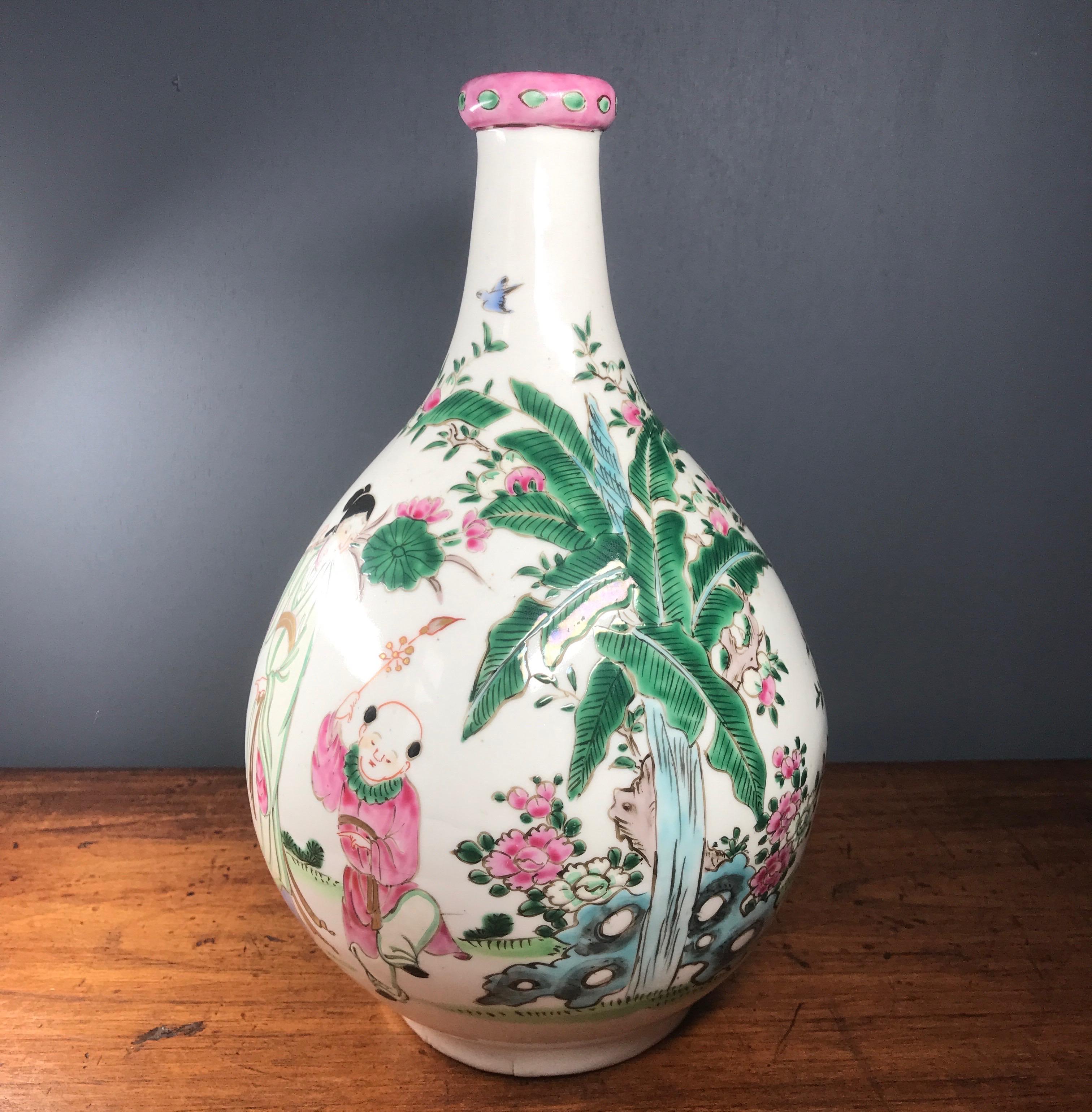 Japanese bottle shape vase, decorated in famille rose colours of pink, green, white, black & turquoise with a lady with children in a garden, including peonies, butterflies, birds, bananas and peaches. 

Unmarked, Meiji period, 19th century.