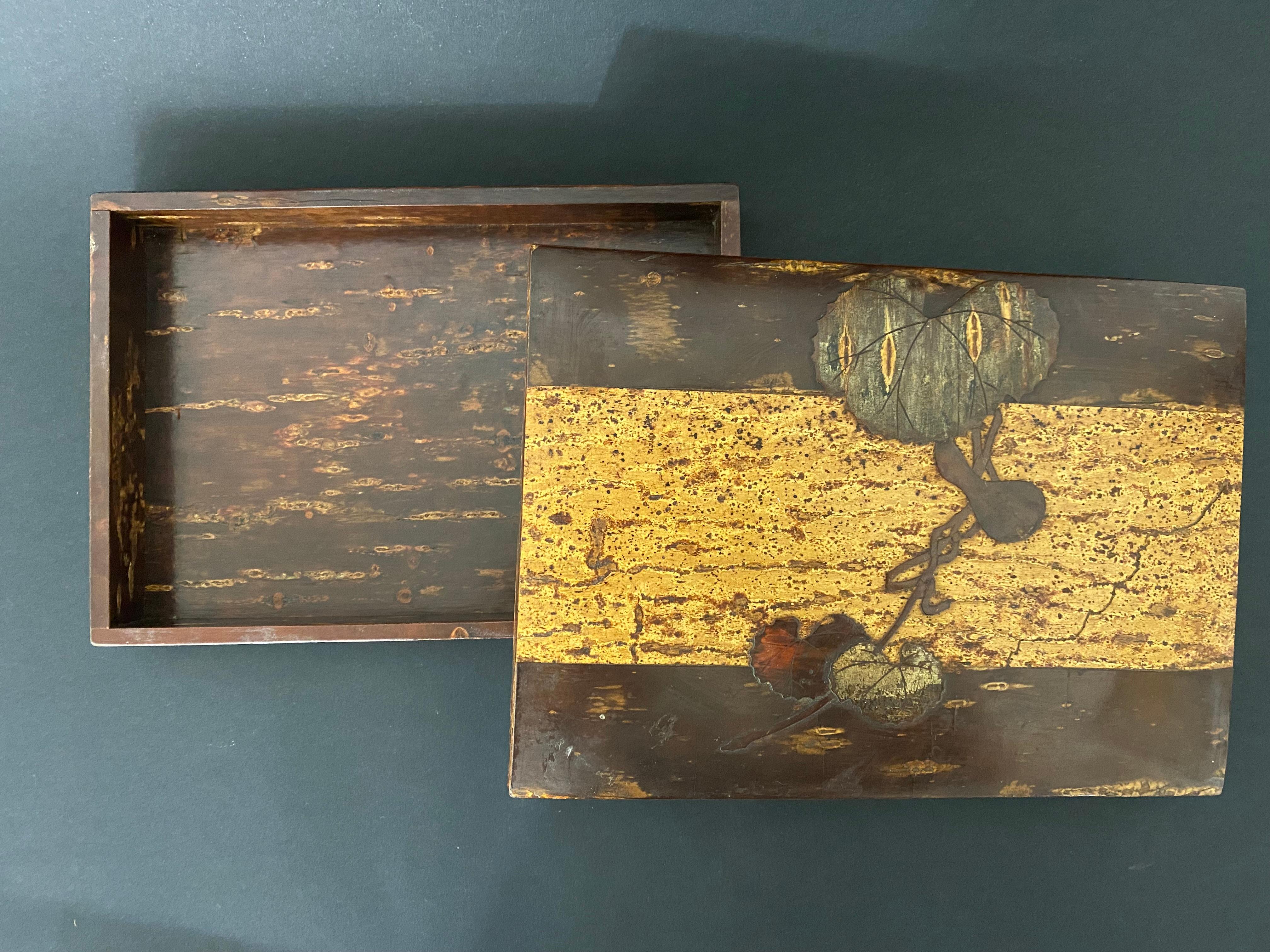 Charmante japanische Schachtel aus dem frühen 20. Jahrhundert. Das Holz ist alt und mit schönen Intarsien auf dem Deckel versehen. Der Deckel ist mit verschiedenen Holzstücken eingelegt, die einen Zweig aus Koloquinten bilden. Durch die Verwendung