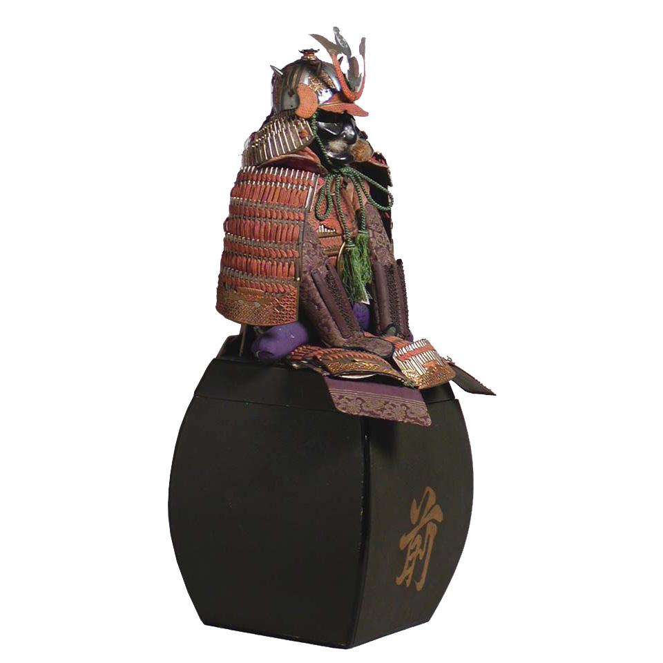 Antique Japanese miniature model of a suit of armor made for the Boy’s day display. Constructed of a lacquered paper cuirass, upper arm guards, protective skirt with silk lacing and metal fittings, large circular oak leaf (kashiwa) crest on the