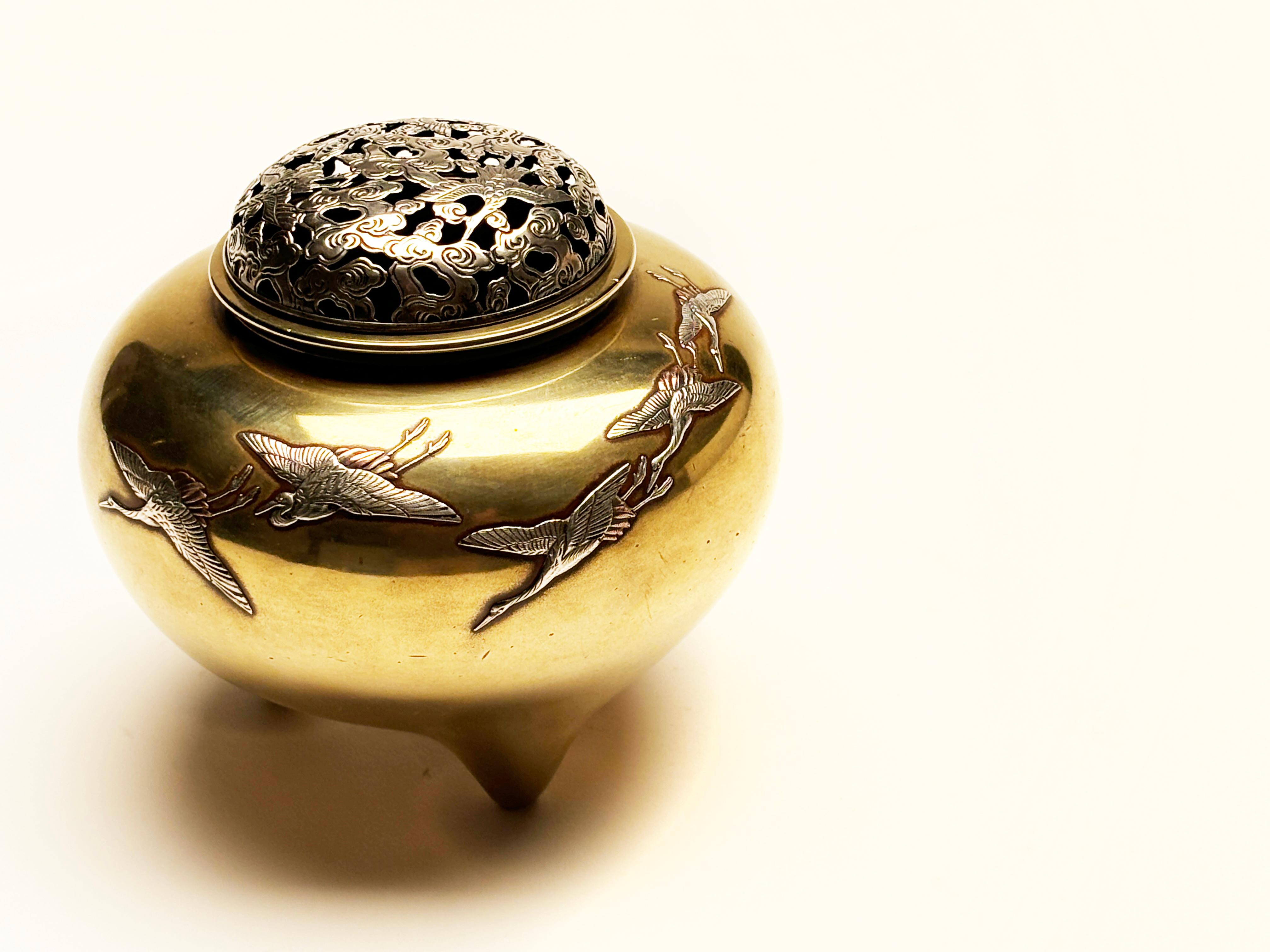 This stunning Koro was crafted in Takaoka, Japan where craftsmen use intricate tooling and expert kills to create the delicate details found in this piece. Crafted of bronze, this Koro portrays intricate sterling silver cranes, accented with copper