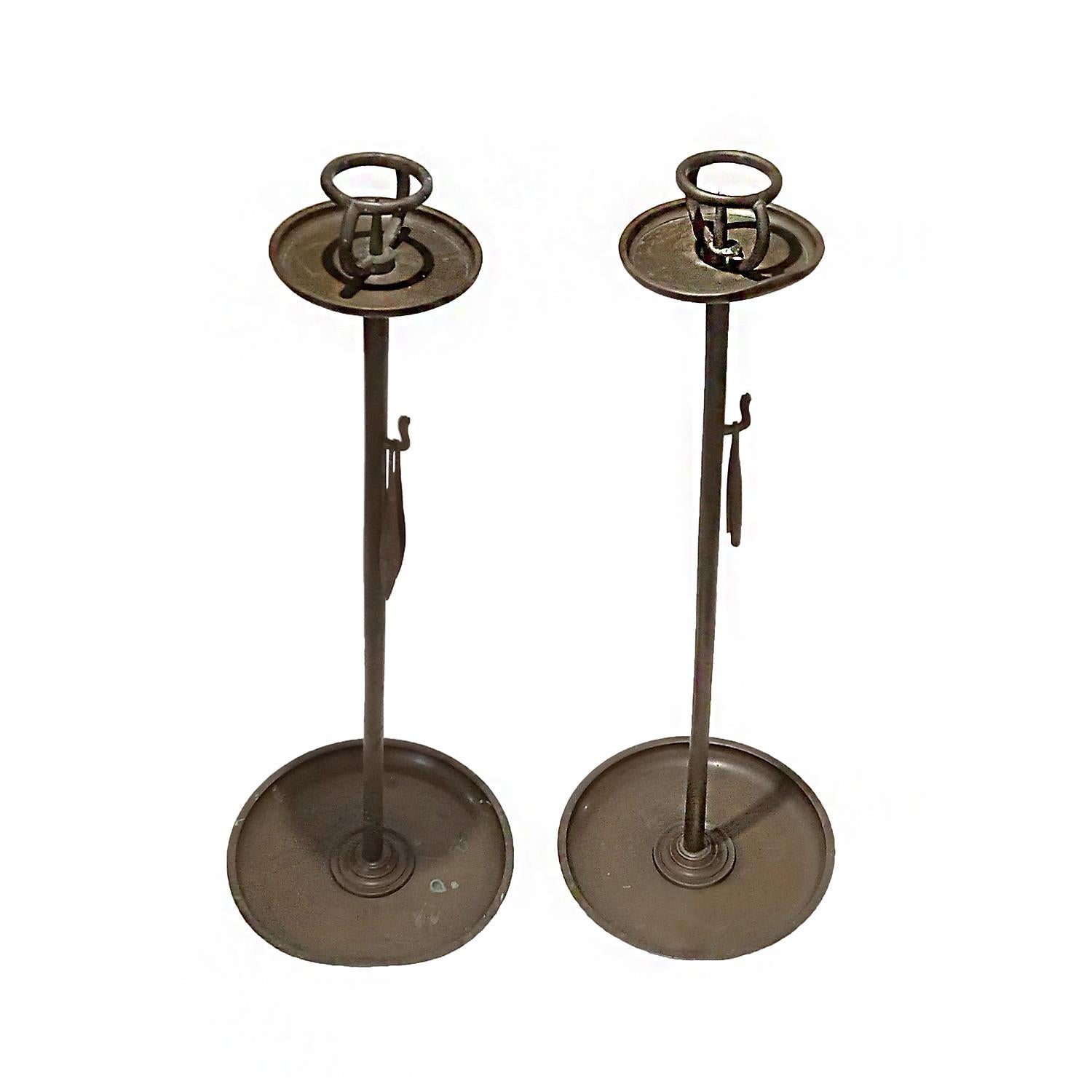 Two tall candlesticks, hand-crafted in bronze, circa 1880. Japan, Meiji Period. 

The base measures 10.25 inches, the height is 29 inches. The top circle plate measures 5 inches, with an inner ring for a 2-inch candle. Both have a patina developed