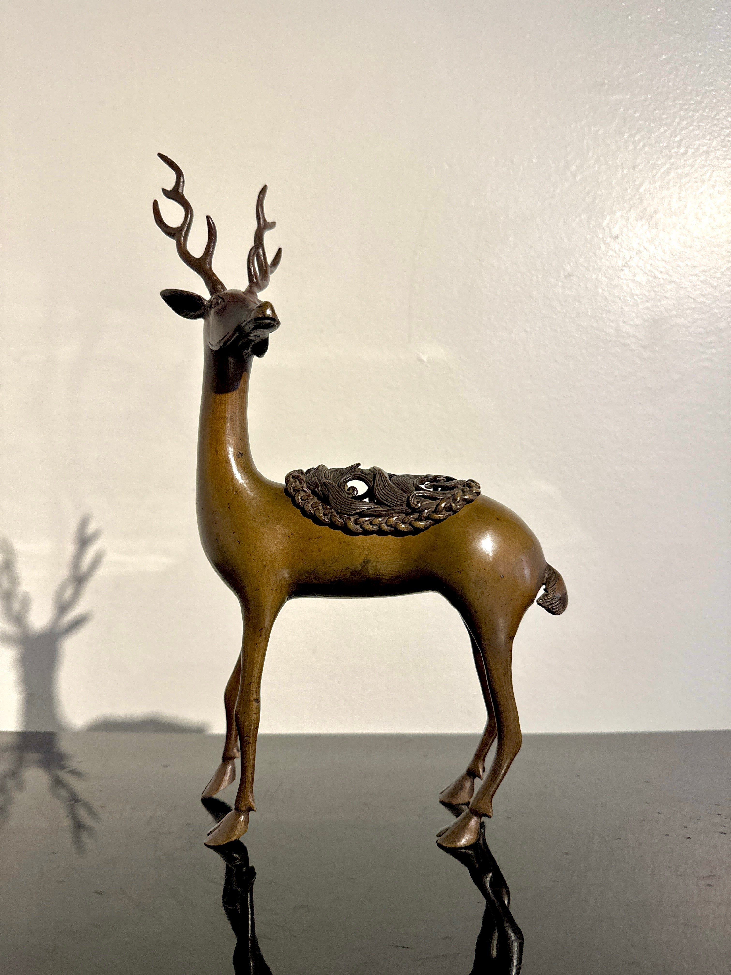 An elegant and ethereal Japanese bronze censer, koro, in the form of a deer, Meiji Period, late 19th century, Japan.

The deer is portrayed standing upon thin, spindly legs, one leg slightly bent, the hoof just off the ground, as if about to take a