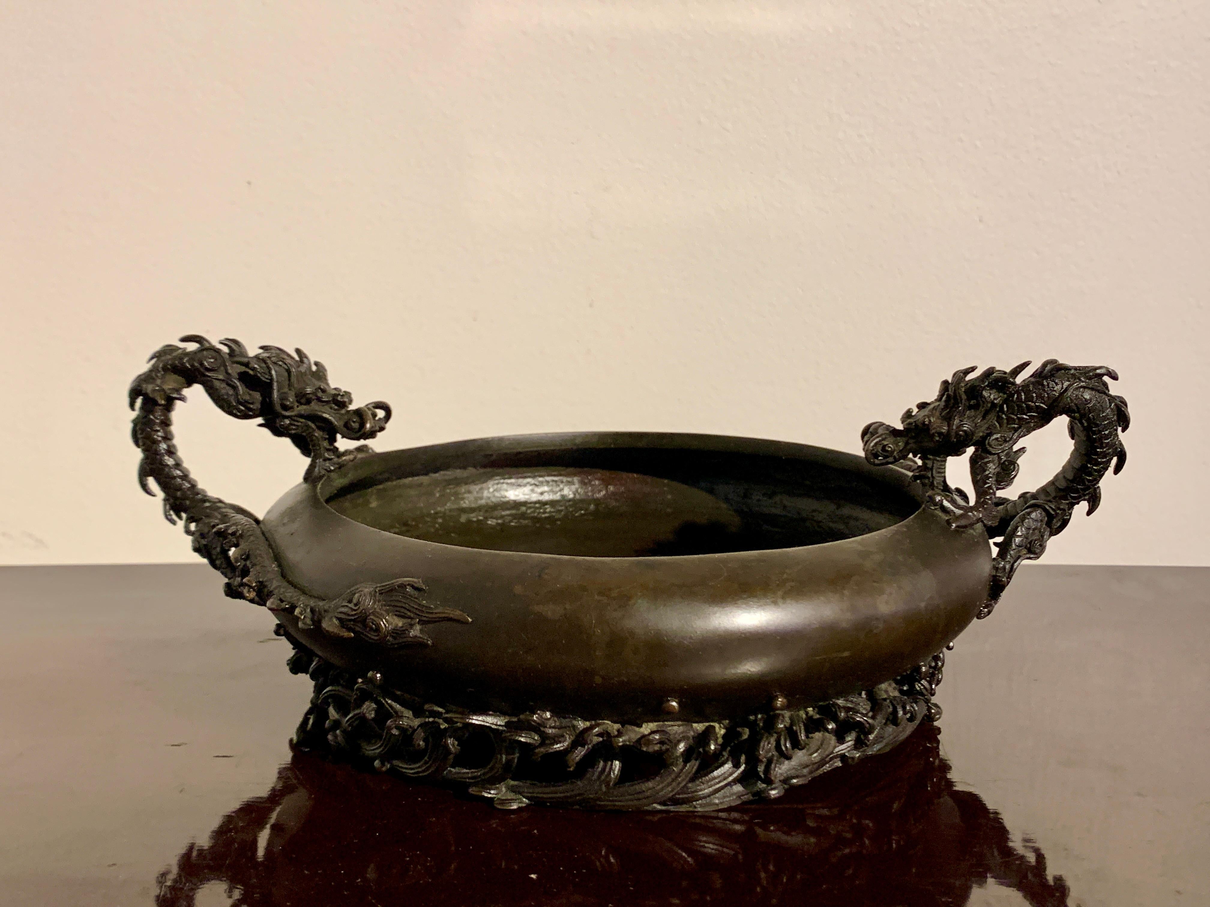 A quiet, yet powerful Japanese bronze suiban, low vessel for ikebana flower arranging, Meiji period, late 19th century, Japan.

The low ikebana vessel, known as a suiban, of cast bronze and formed as a shallow basin with a pair of dragon handles,