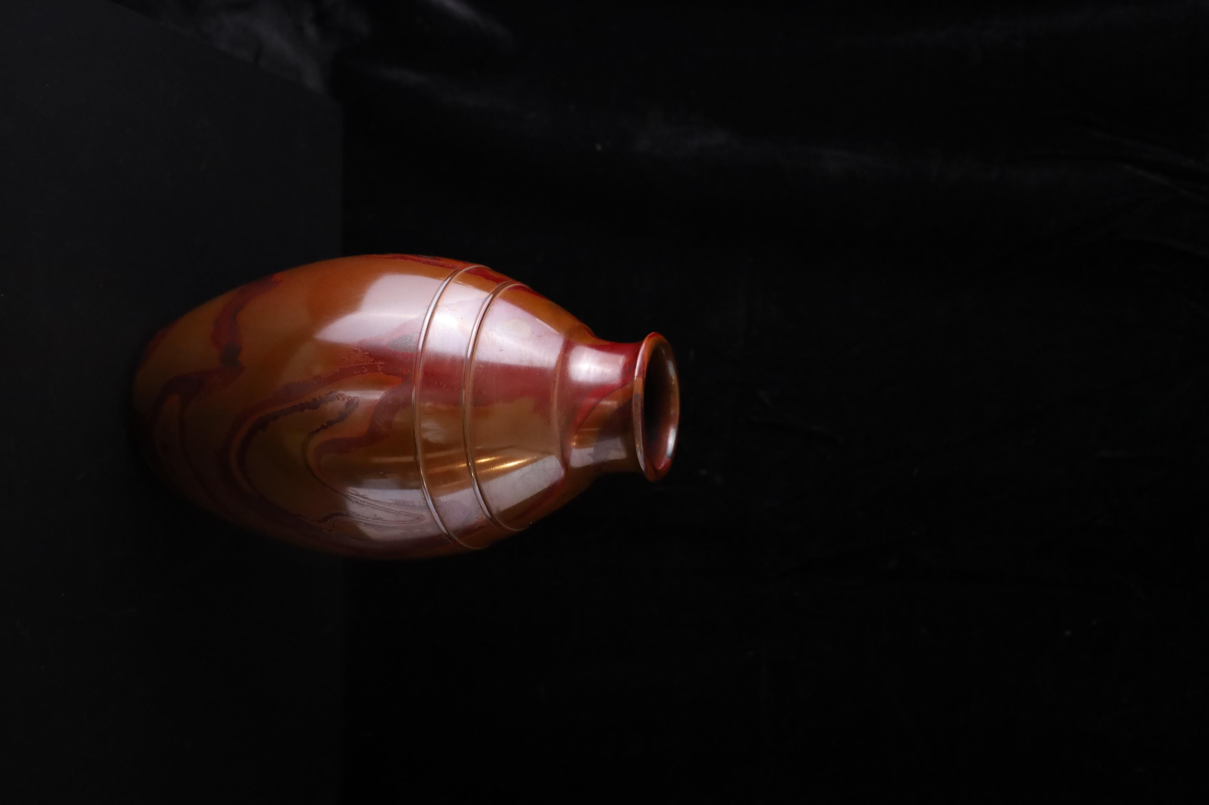 A striking Japanese bronze flower vase (花器, kaki), cast using the traditional chūdō (鋳銅) technique and showcasing the rare hon-yaki (本焼色) patina. This rich, swirling finish is achieved through a natural oxidation process developed over time and