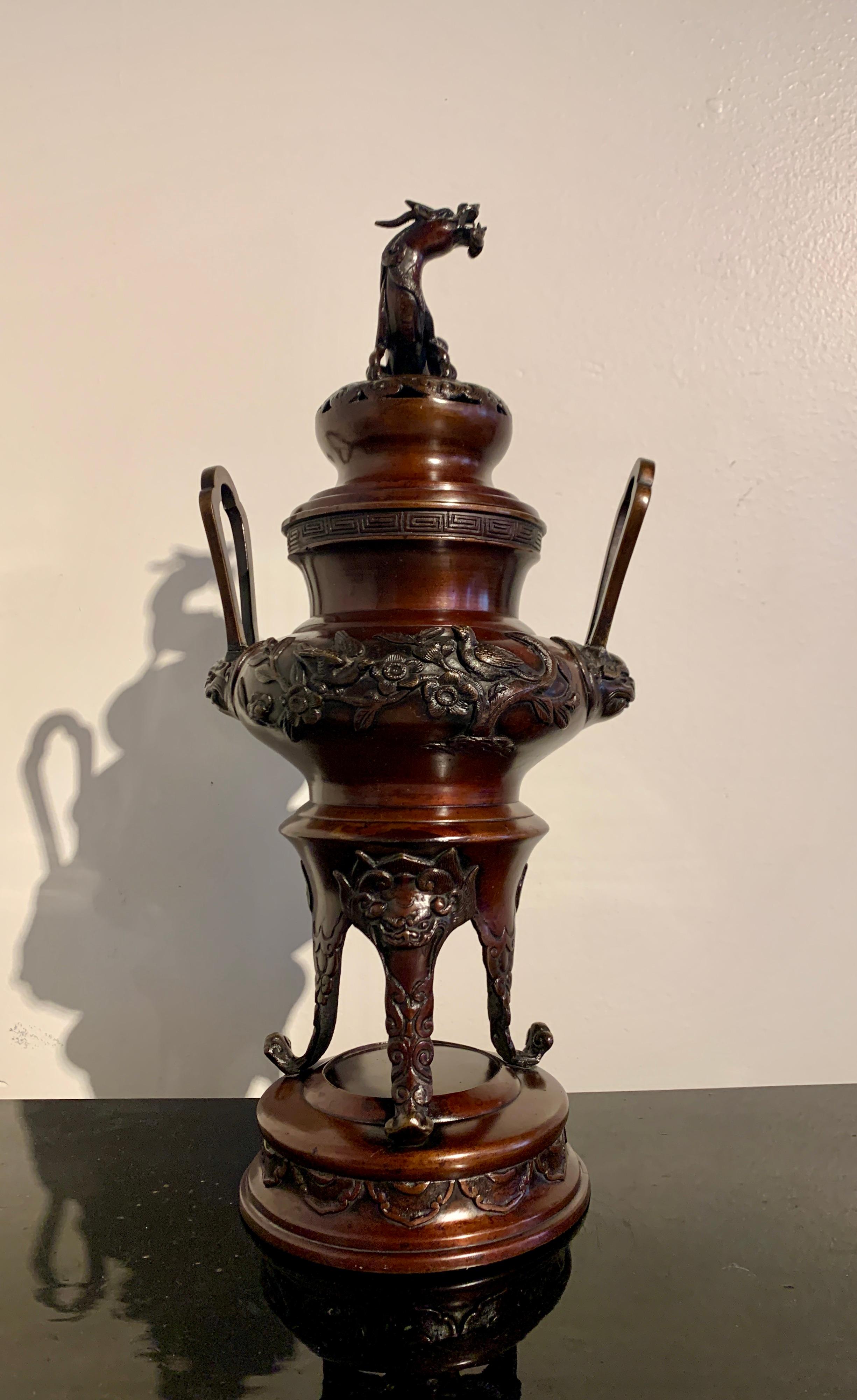 An elegant Japanese cast and lacquered bronze incense burner, koro, topped with a mythical kirin, Taisho Period, circa 1920, Japan.

The tall koro of tripod form, with three elegant legs with outward curved feet resting on an integral circular
