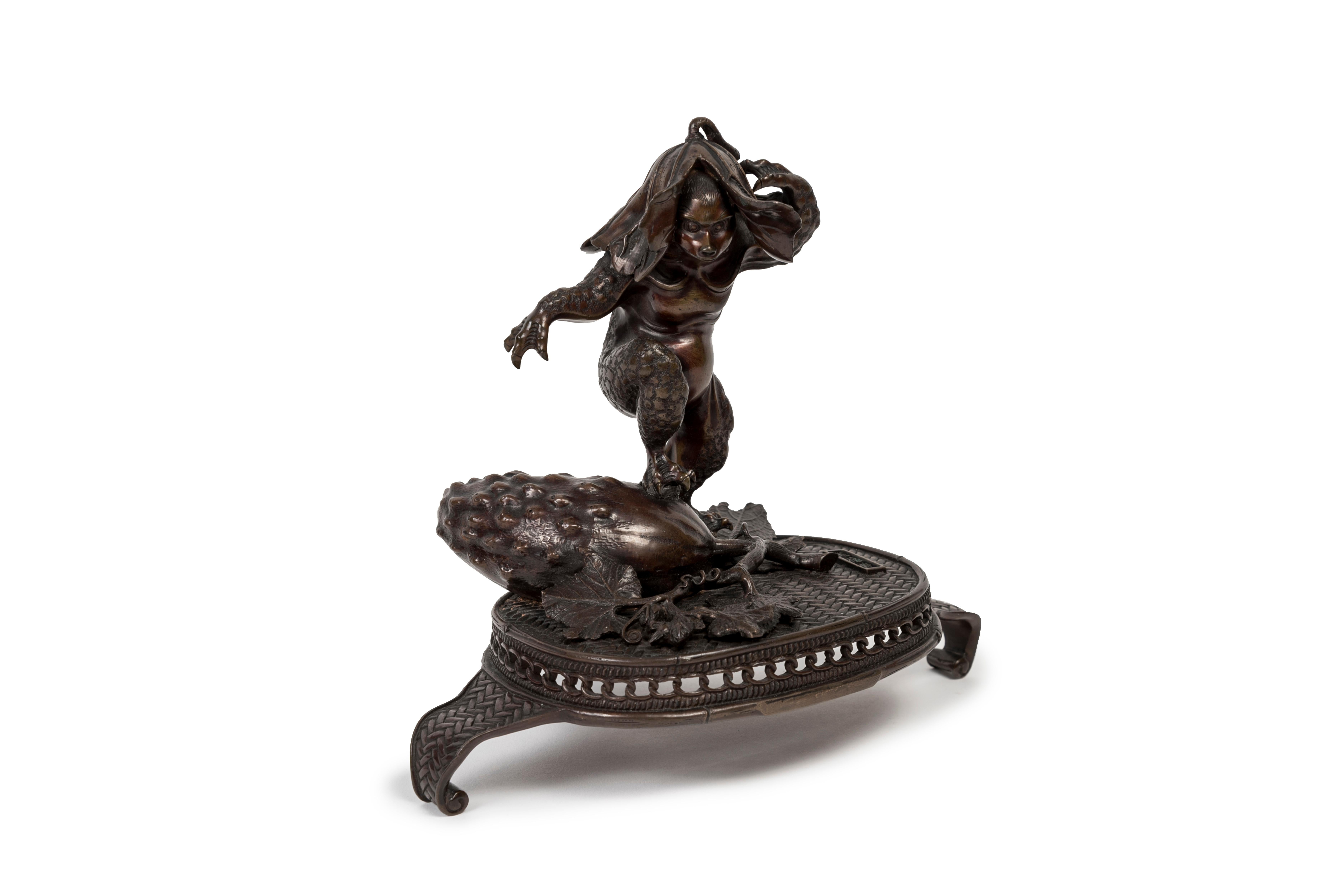 Dark brown patina bronze figure of a standing kappa with its right leg leaning on a cucumber. The figure is put on four-legged rattan-like bronze stand.

The kappa (??) is a aquatic creature taken from Japanese folklore having the appearance of an