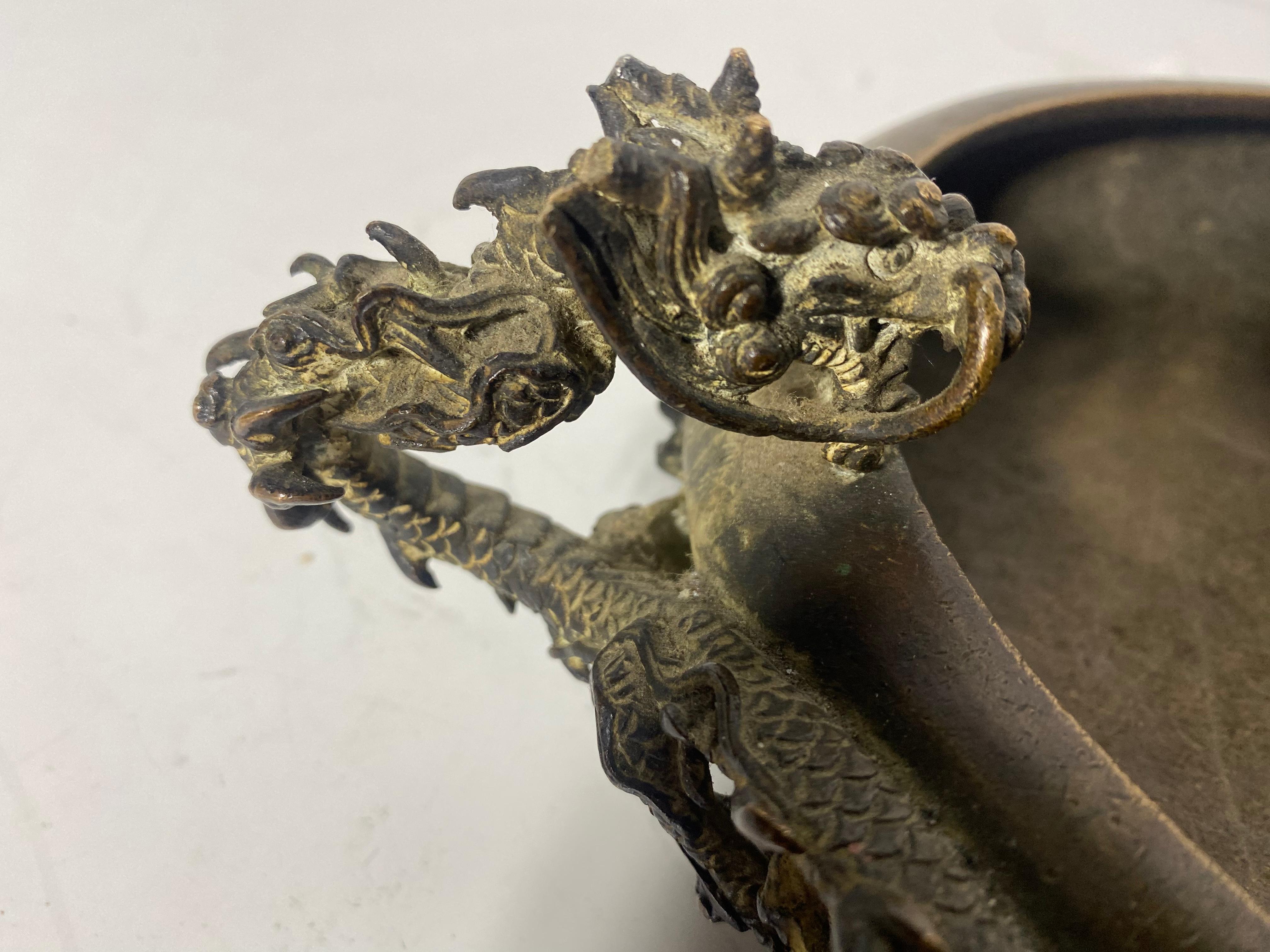 JAPANESE BRONZE BOWL - Meiji Period Low Oval Bowl with two full-body writing dragon handles and reticulated wave form foot, maker's mark on underside. 3 3/4