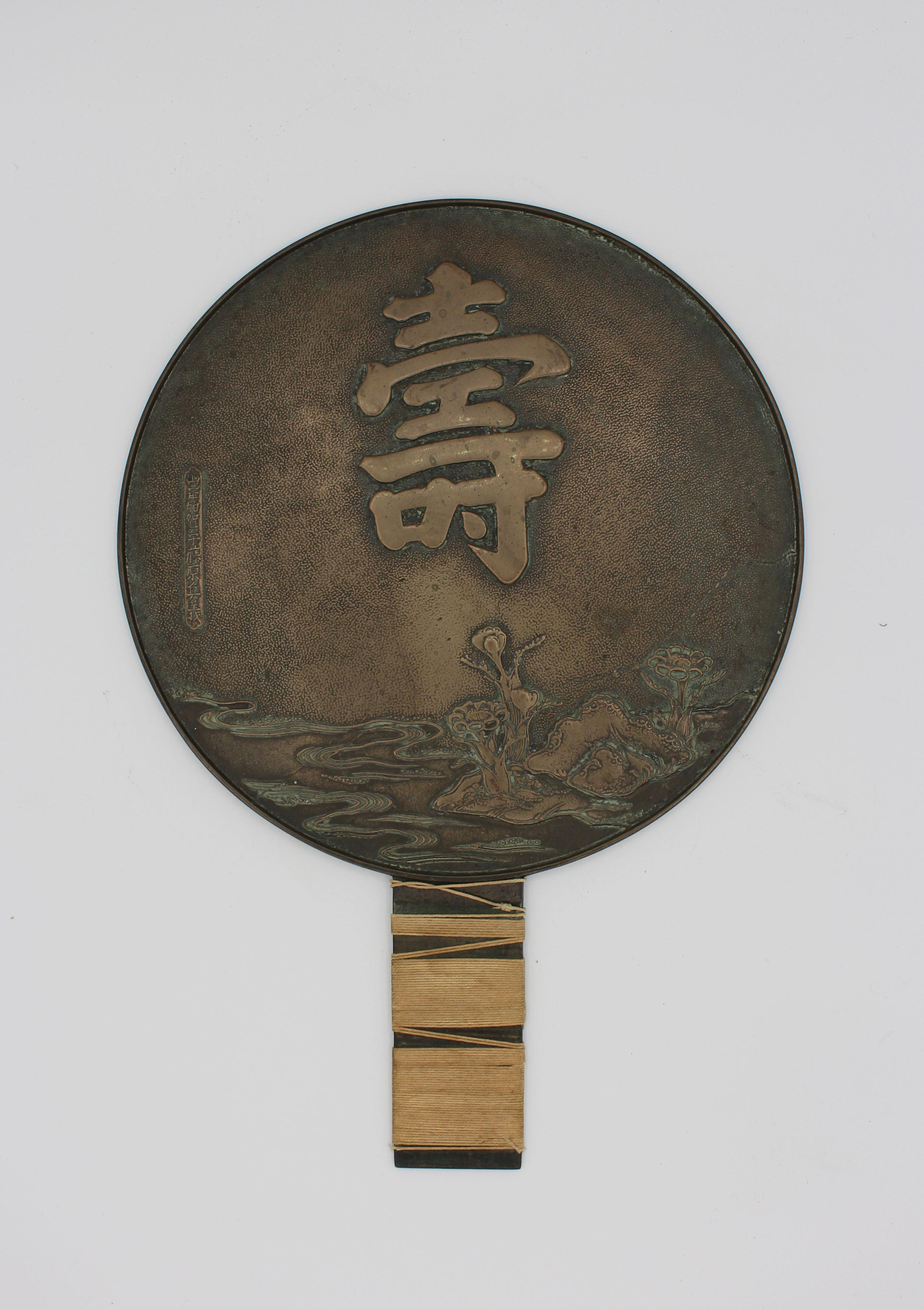 Japanese bronze mirror. Great surface colors; old string handle wrap, Meiji period 1868-1912. Wear from polishing. Extensive inscription. 9 5/16