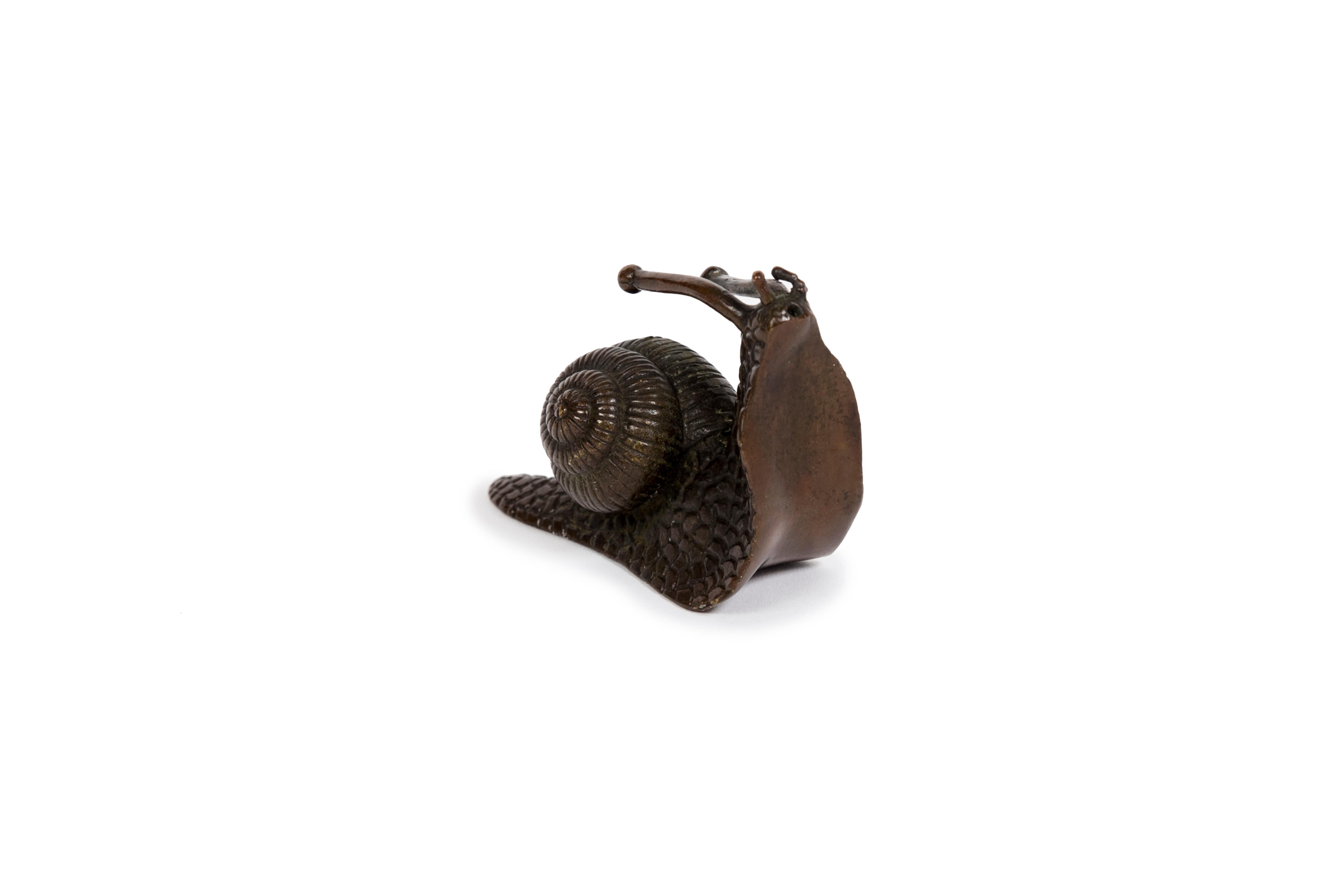 Bronze à patine brune représentant un escargot à la pose très intéressante. Sa pose angulaire suggère qu'il pourrait être exposé de manière à imiter un véritable escargot montant ou descendant le long d'un mur. La texture de la coquille et de la