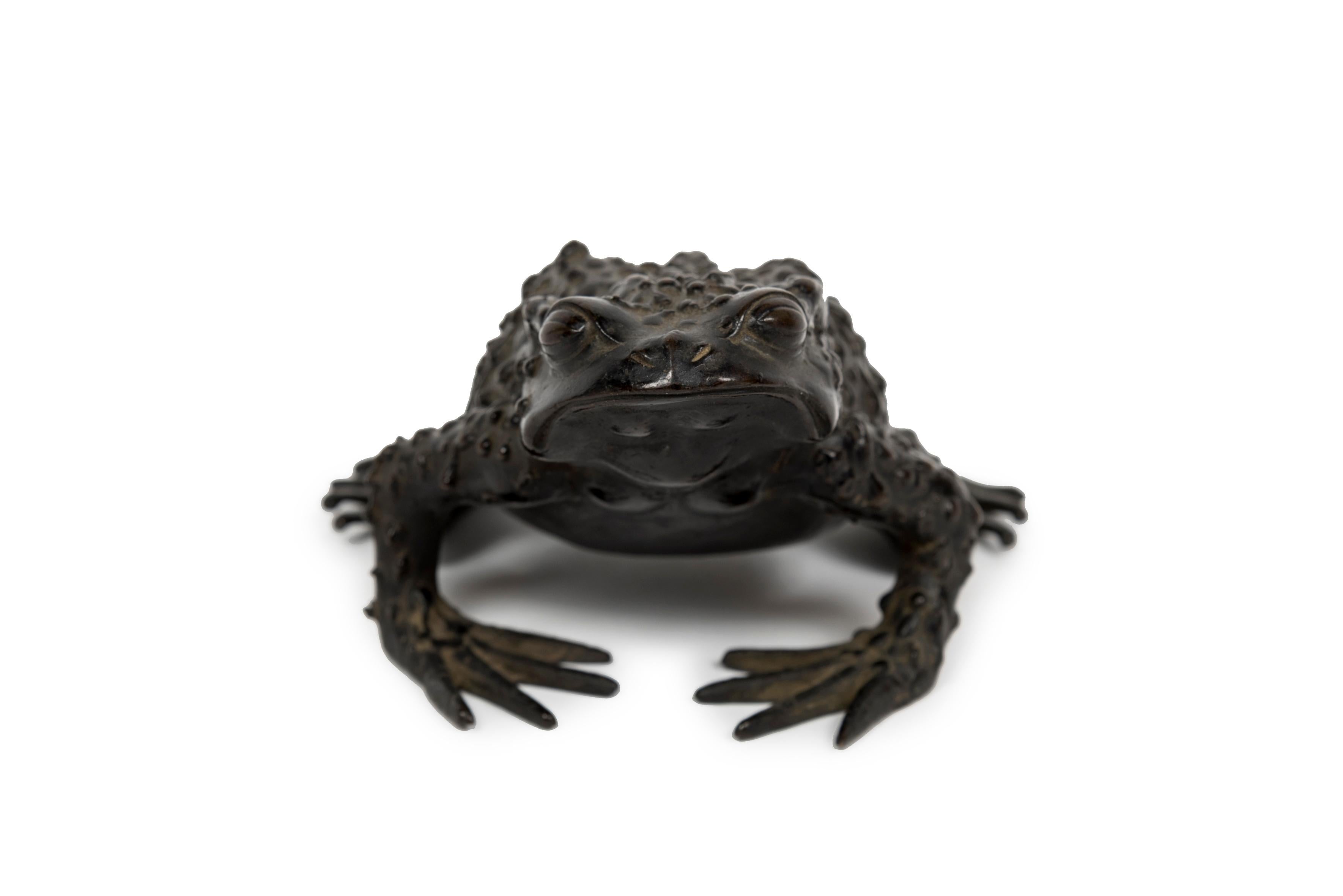 Okimono bronze sculpture of a toad. 
The toad or the frog (kaeru) is associated with good luck and wealth. Kaeru means both “toad” or “frog” and “to return home” in Japanese. This meaning is due to the toad’s ability to return each year to the pond