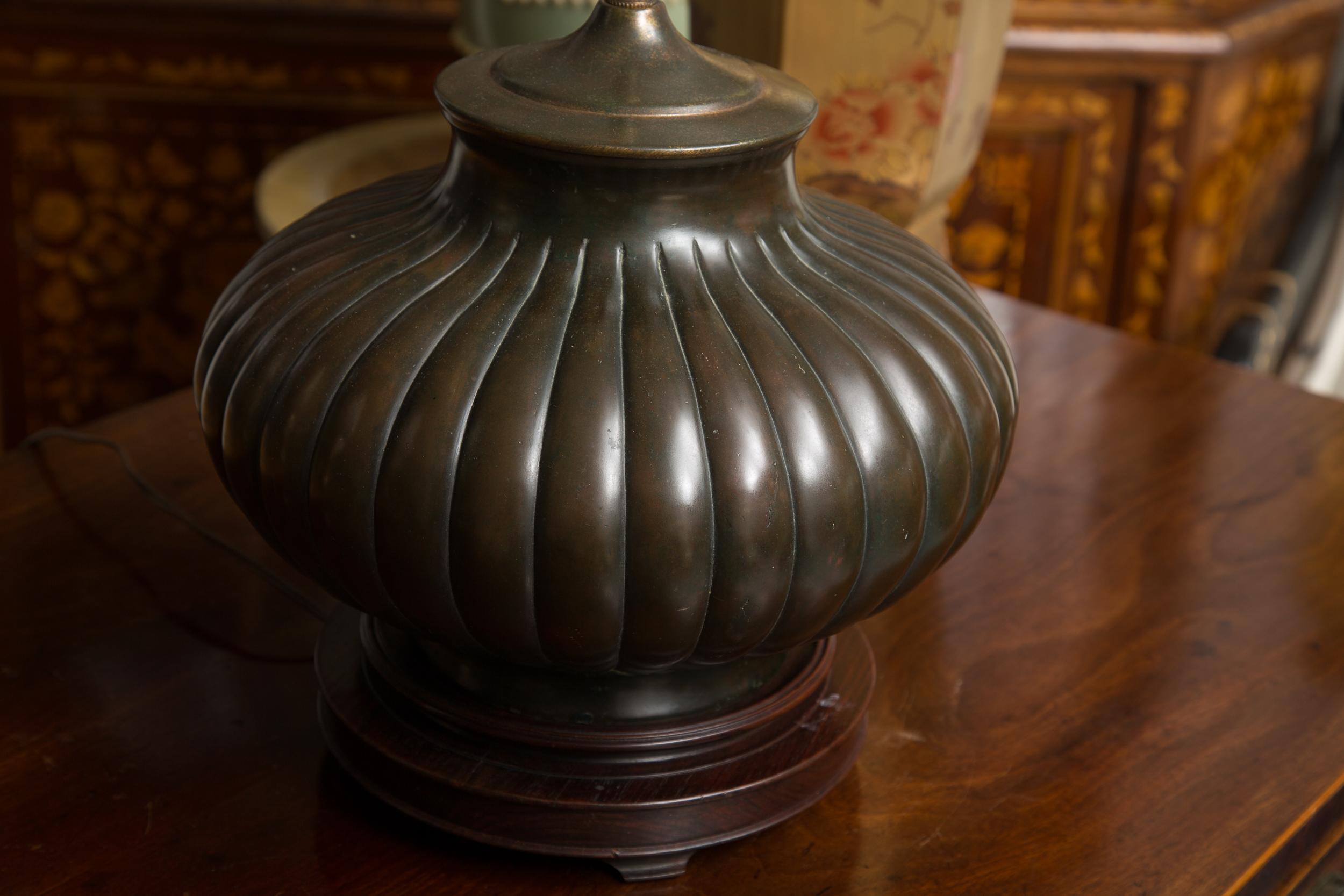 This is a striking Japanese onion-from bronze lamp fitted to a carved wood base.