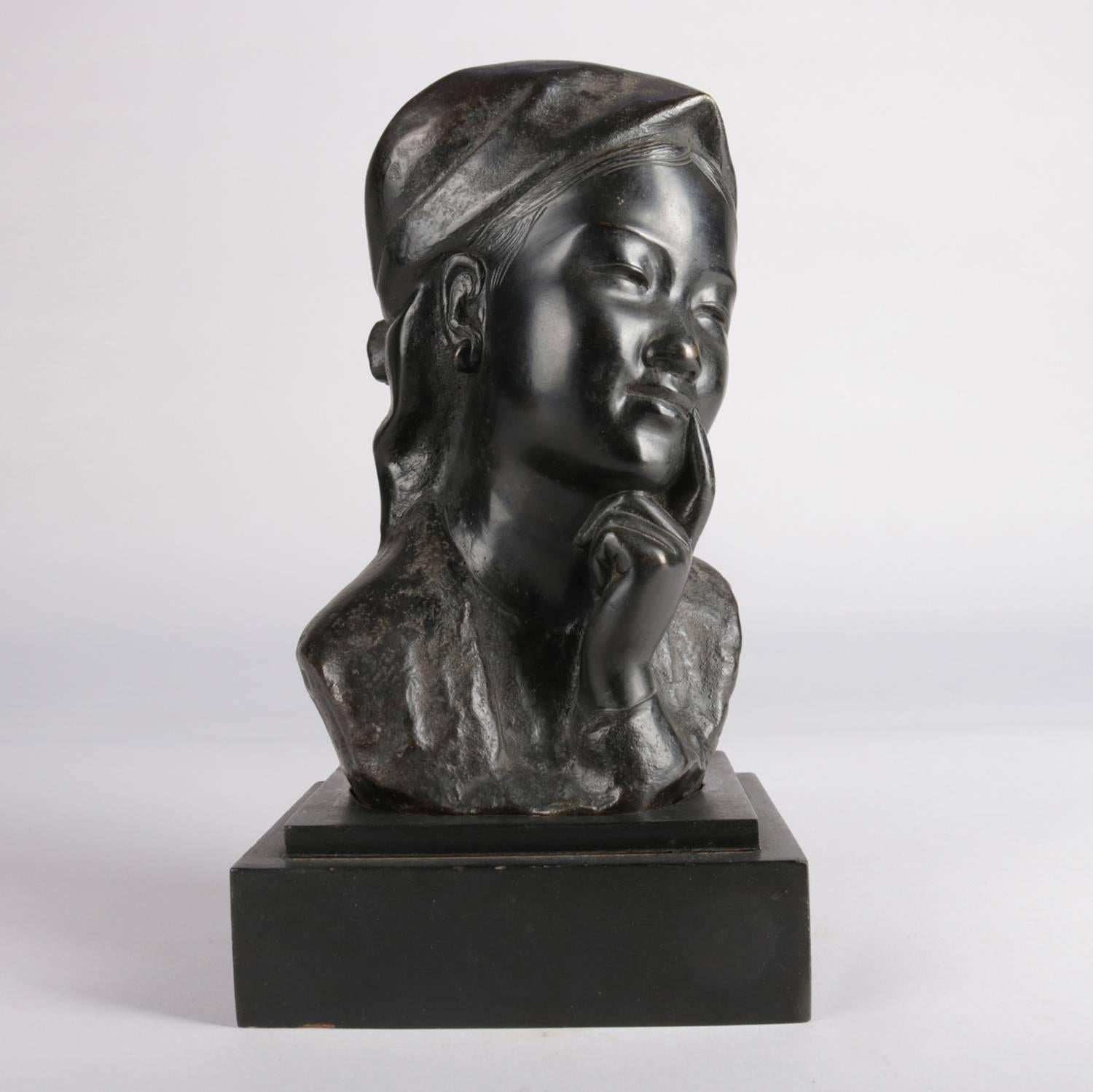 Japanese cast bronze portrait bust sculpture features pensive young girl in traditional garb and with head covering or scarf, seated on ebonized wood base, 20th century

Measures: 10