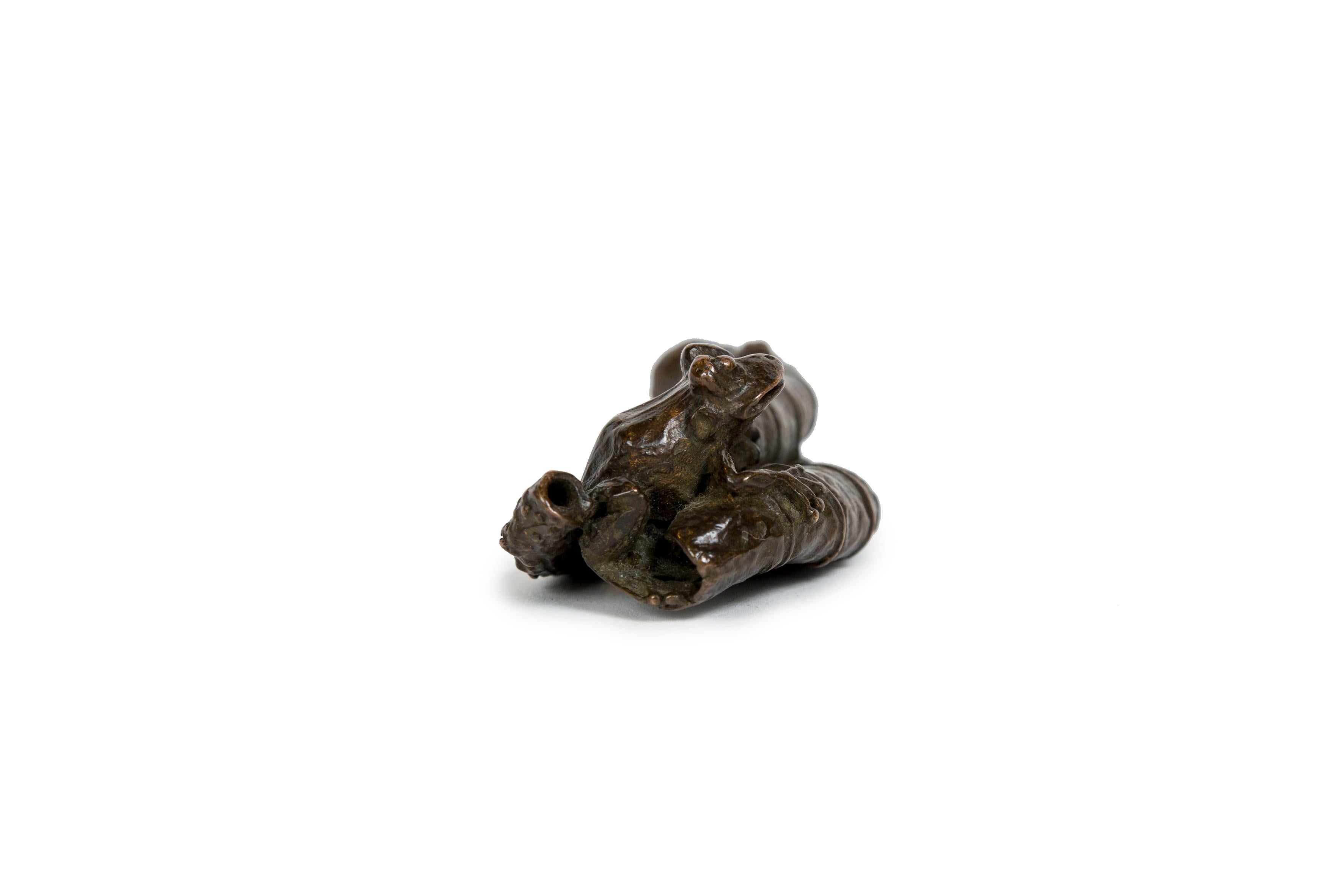 Calco Scultura giapponese in bronzo di una rana che si nasconde in una foglia di loto (Okimono) in vendita