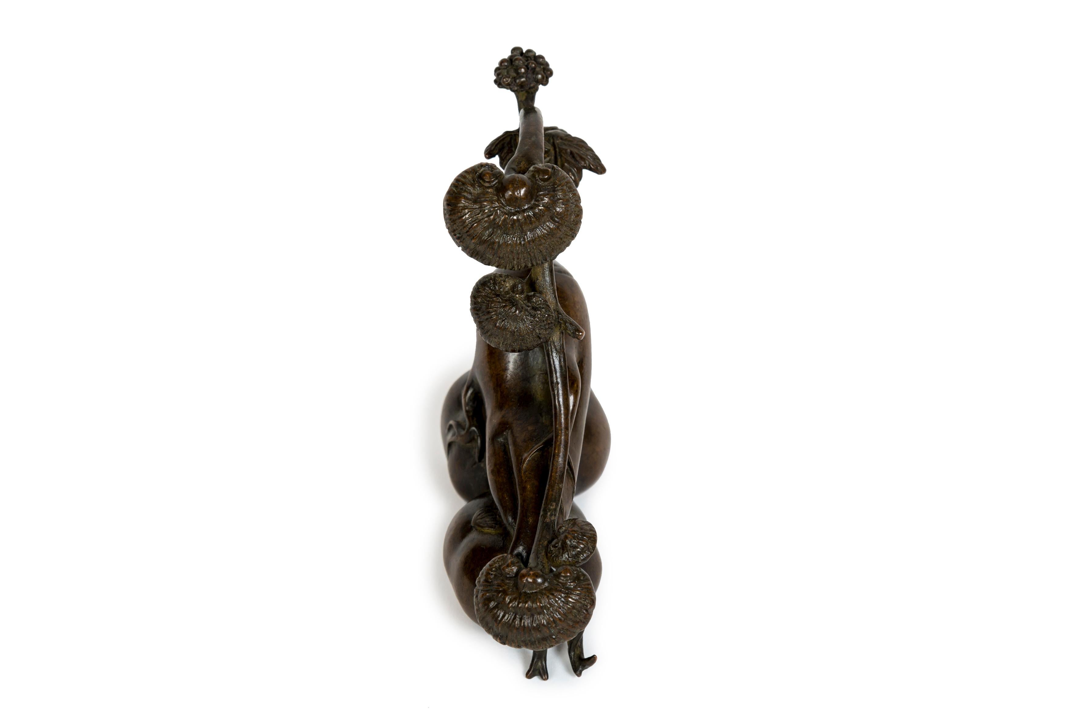 Scultura in bronzo che rappresenta un gruppo di funghi genoderma che si sviluppano sul lungo gambo di una radice di Ginseng che poggia su due kaki. Logicamente questa radice sarebbe Panax ginseng, la razza asiatica, infatti il peduncolo è più lungo