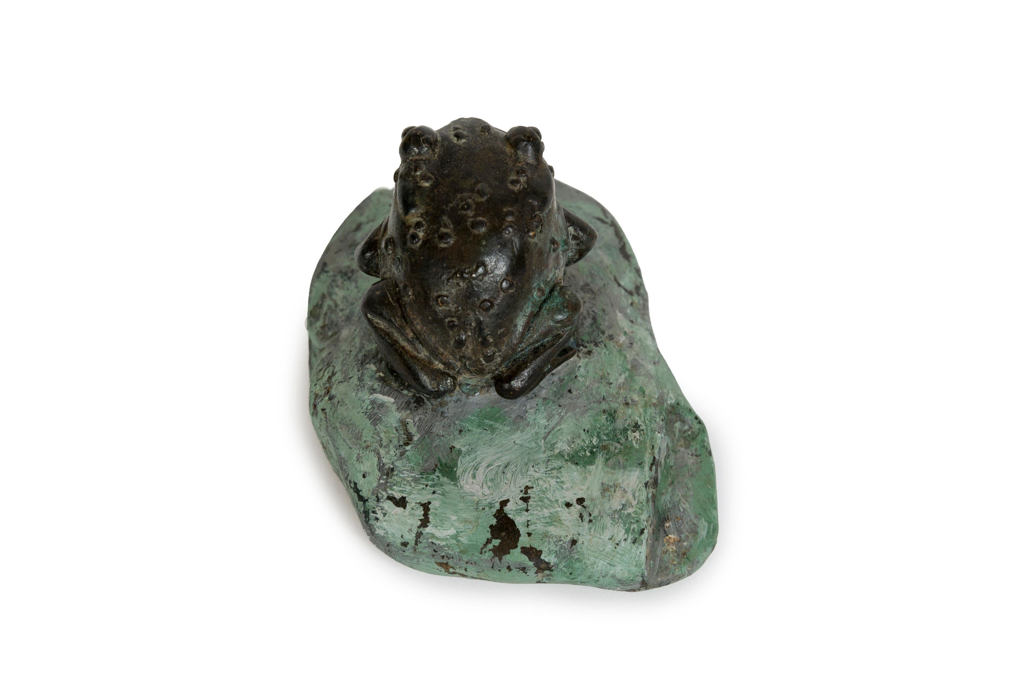Cast Japanese bronze sculpture of a grotesque toad seated on a pinted stone