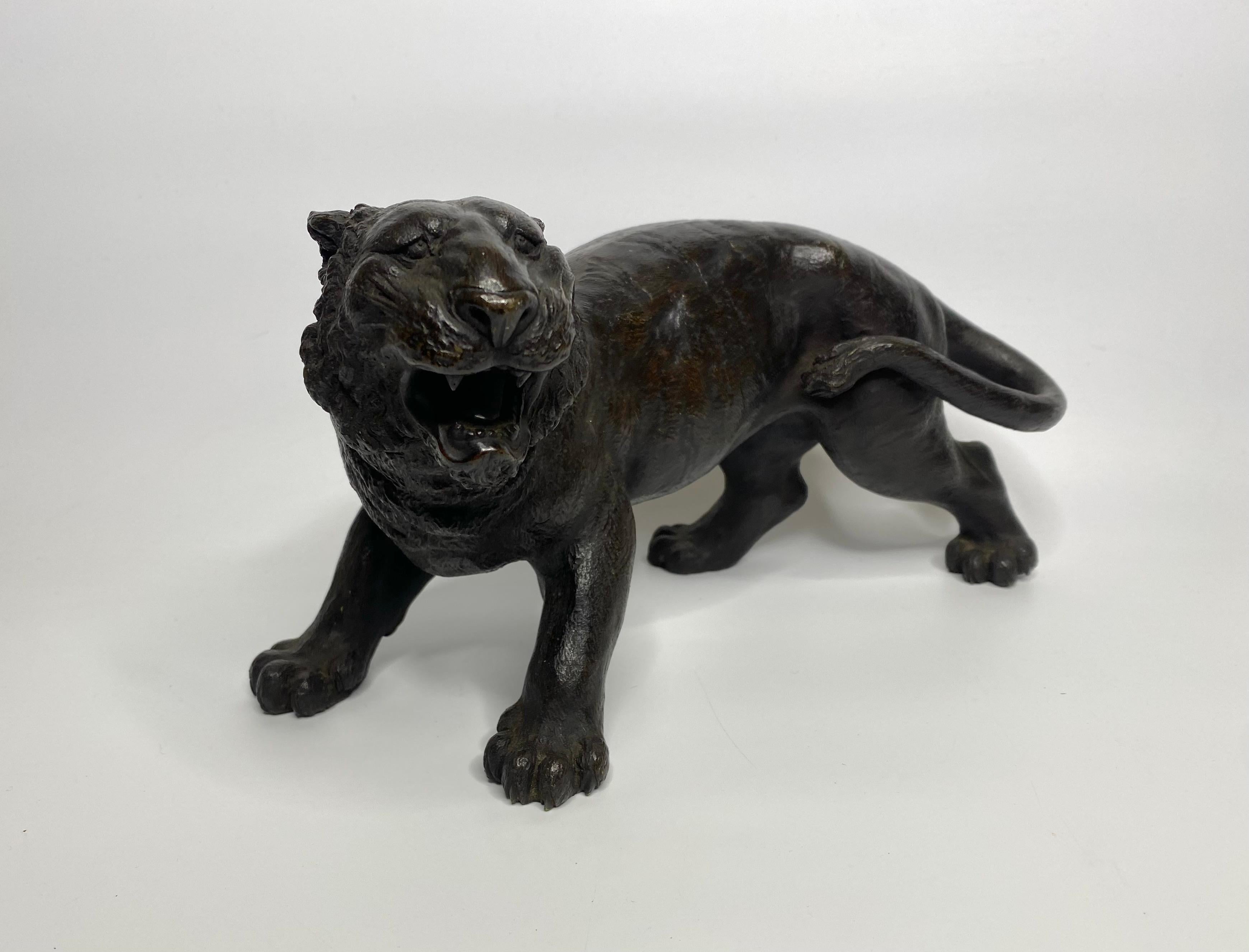 Cast Japanese bronze tiger, signed Yoshikuza, Meiji Period.