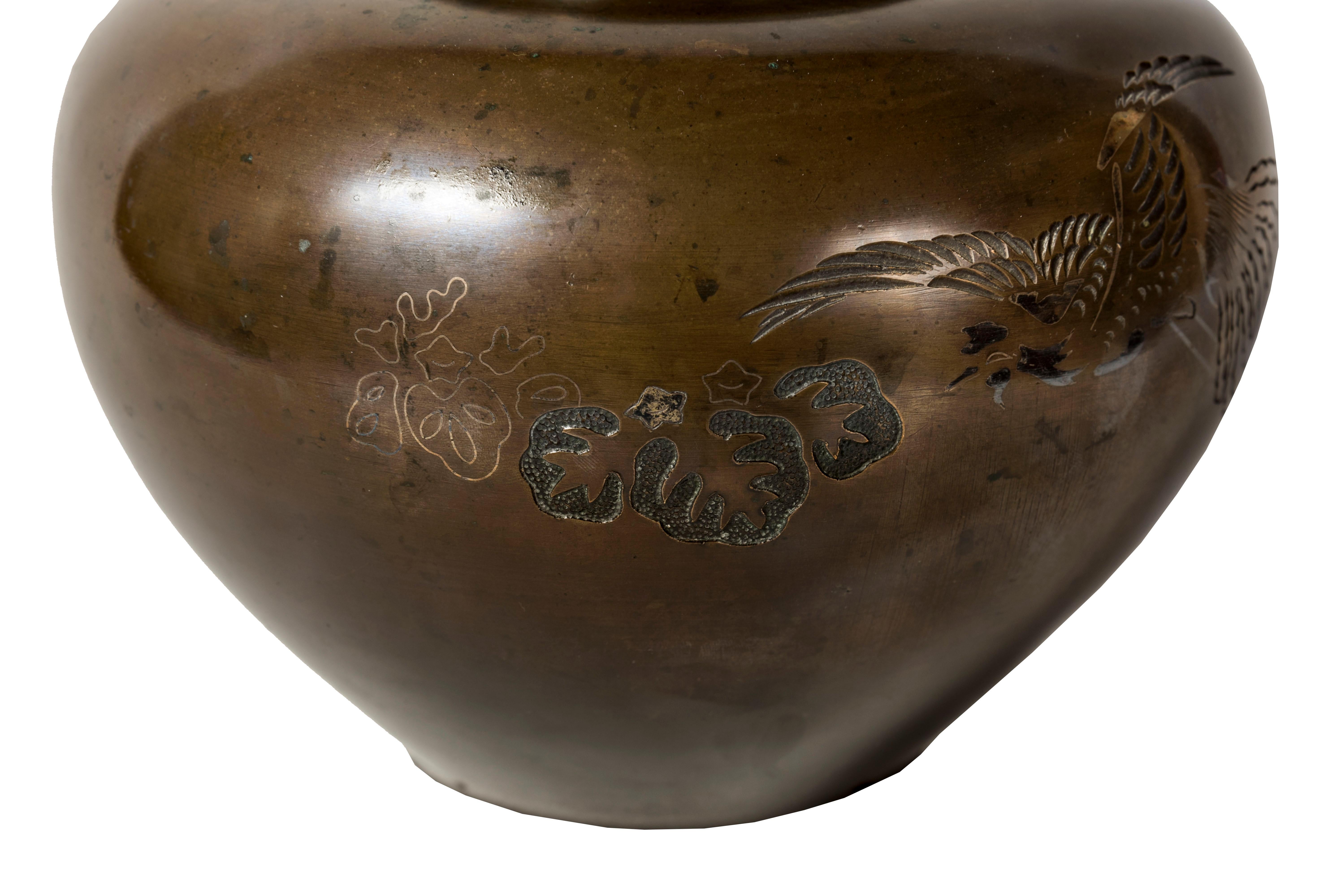 
Patinated bronze vase decorated with a flying phenix and paulownia leaves. The phoenix has imperial and solar symbolism. This bird of good omen also embodies virtues from the teaching of Confucius (such as goodness, righteousness, and wisdom).
