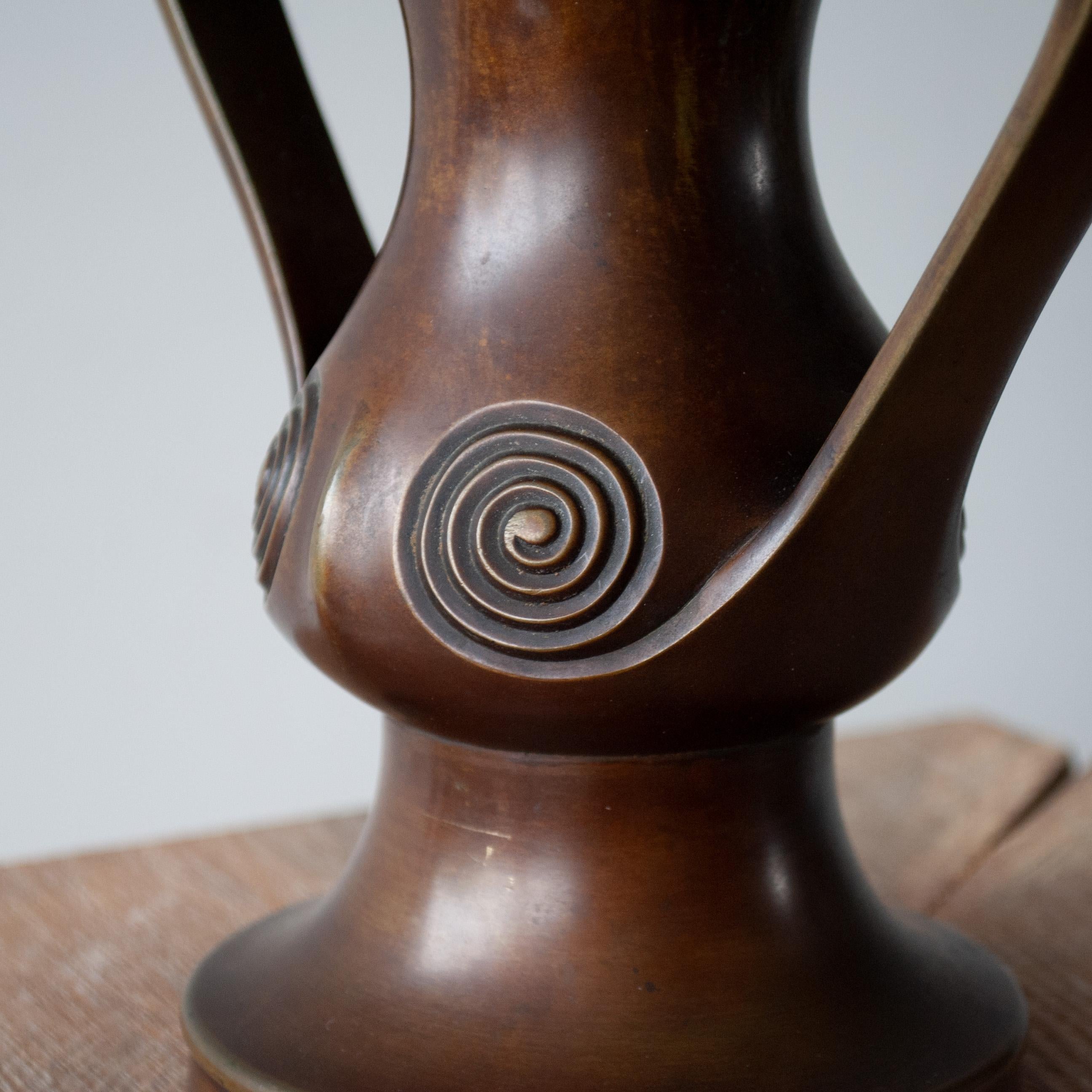 A Japanese solid bronze Mimikuchi handled vase with crisply detailed spiral design on a beautifully rounded body. 
This rare piece dates from the early to mid 1800's. A very fine example of Japanese Edo period design and master-craftsmanship.