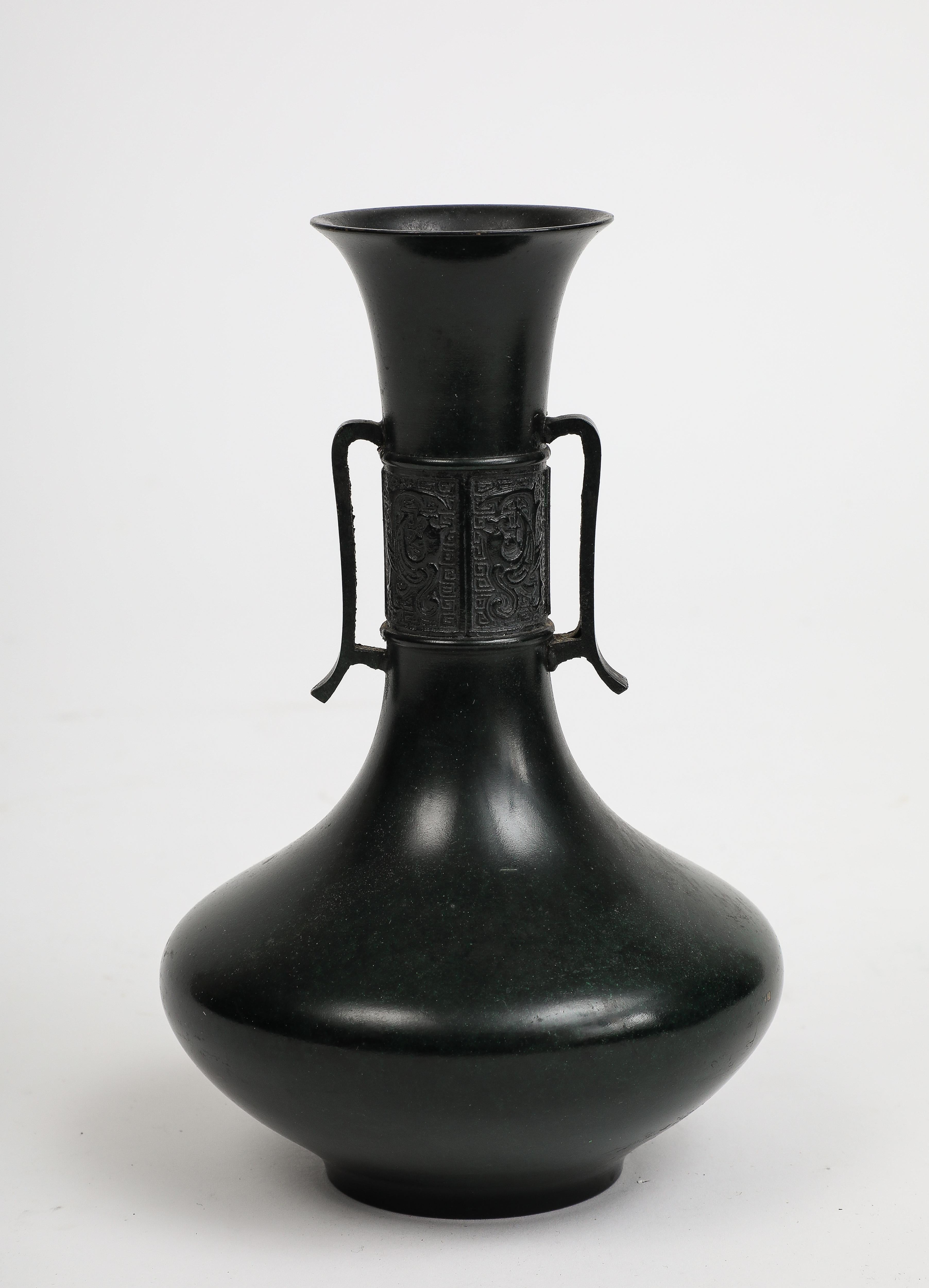 20th century blackened bronze Japanese vase, with slim handles and raised bronze casting on the neck. 