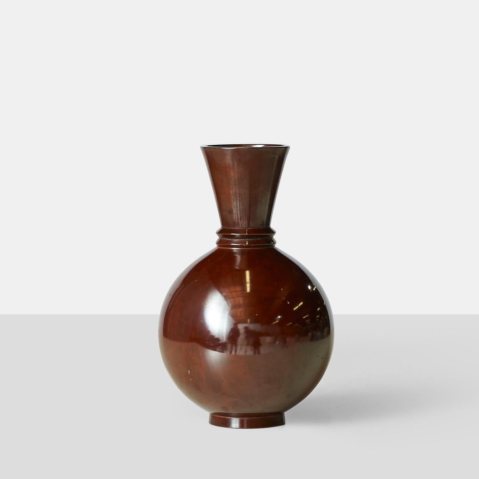 A decorative glossy Japanese modernist bronze vase with a fluted neck, with some mild patination. Signed on the base. 