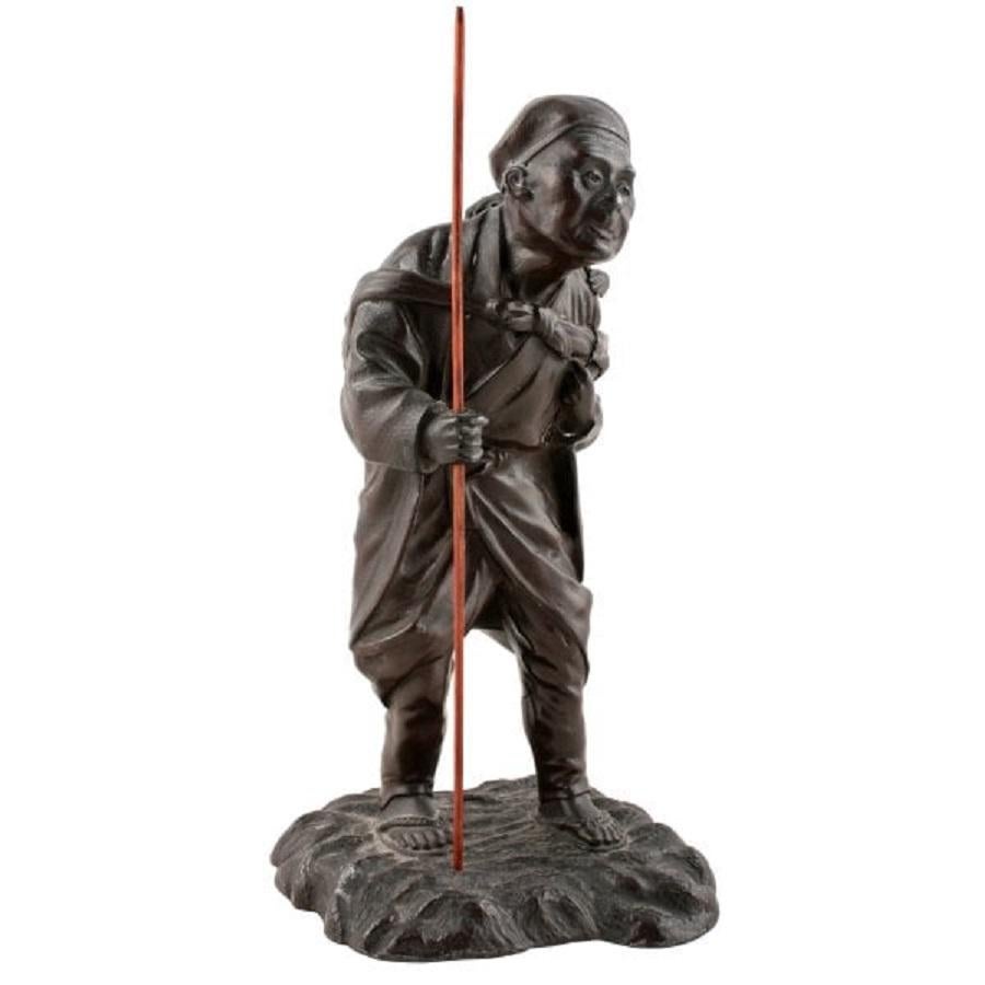 A late 19th century Japanese bronzed metal figure.

The figure is of an elderly Gentleman with a monkey on his back.

The figure has a bag strapped around his shoulders on which the monkey stands and holds a thin wooden staff in his right