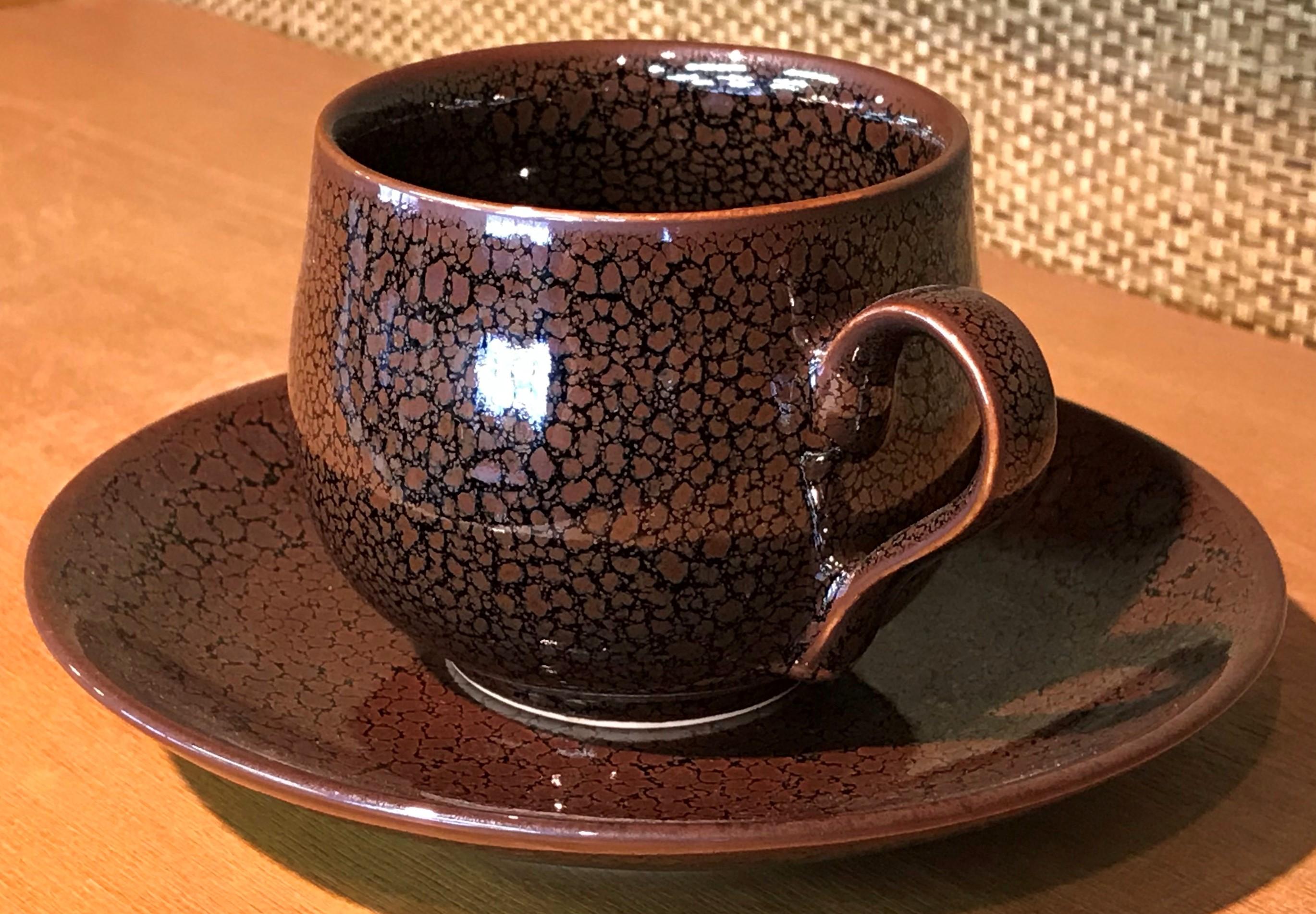 Unique contemporary Japanese porcelain cup and saucer, hand-glazed in stunning signature brown, a signed work by highly acclaimed award-winning master porcelain artist from the Imari-Arita region of Japan. 

In this extraordinary piece, the artist