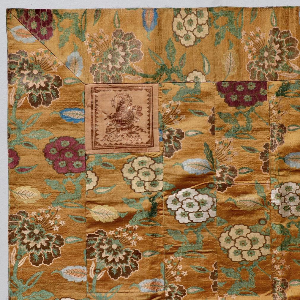 Japanese Buddhist Priest’s Silk Mantle (kesa) with Guardian King Appliqués, dai-e format composed of 13 vertical panels of varying widths and patches surrounded by a broad border, all of the same sumptuous silk brocade fabric. The golden silk ground