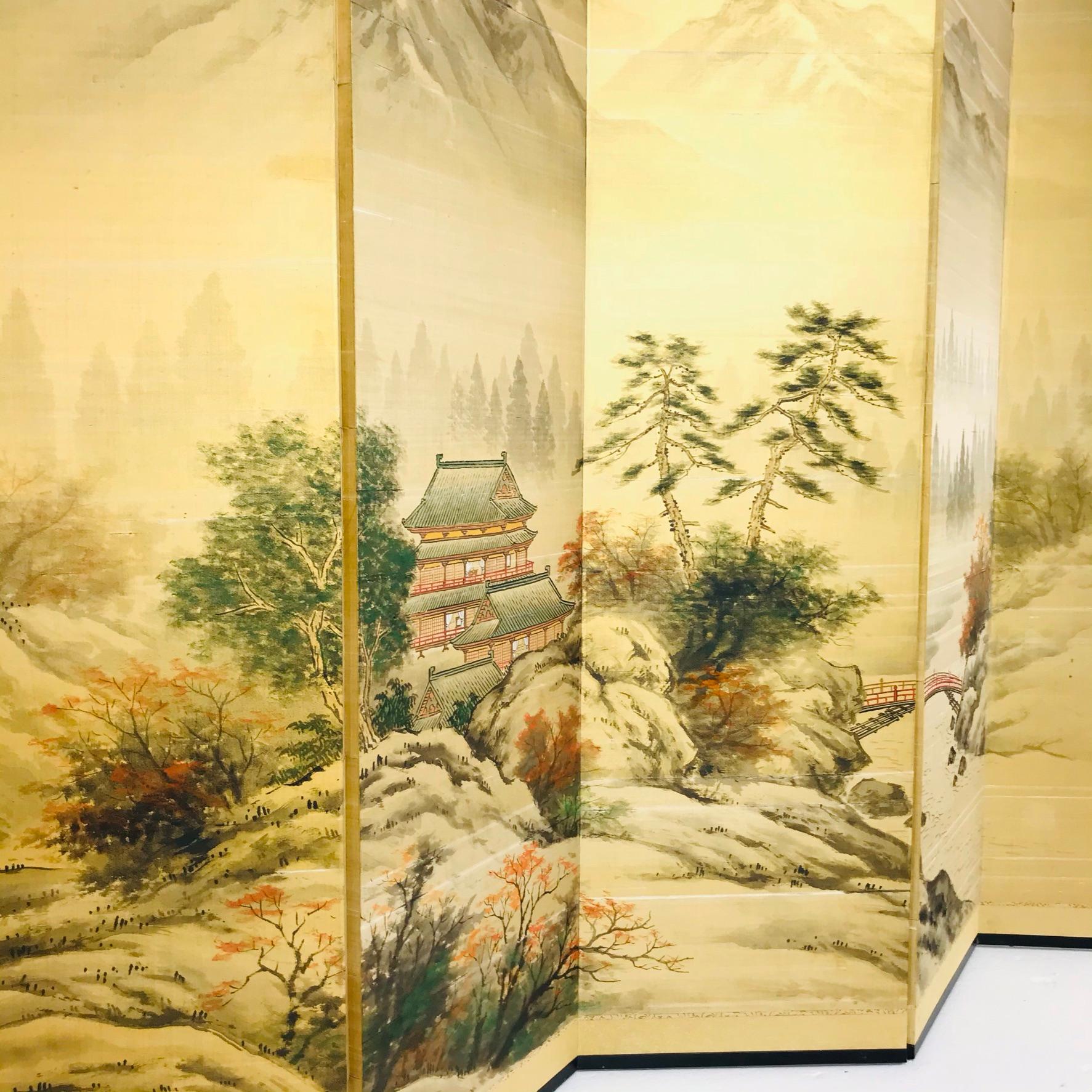 Beautiful early-mid 20th century 6 panel Japanese Byobu folding screen. It is signed and features hand applied painted scenes of cloudy mountains and trees in gold tones.

The corners and sides of the wooden frame have lovely hand hammered and