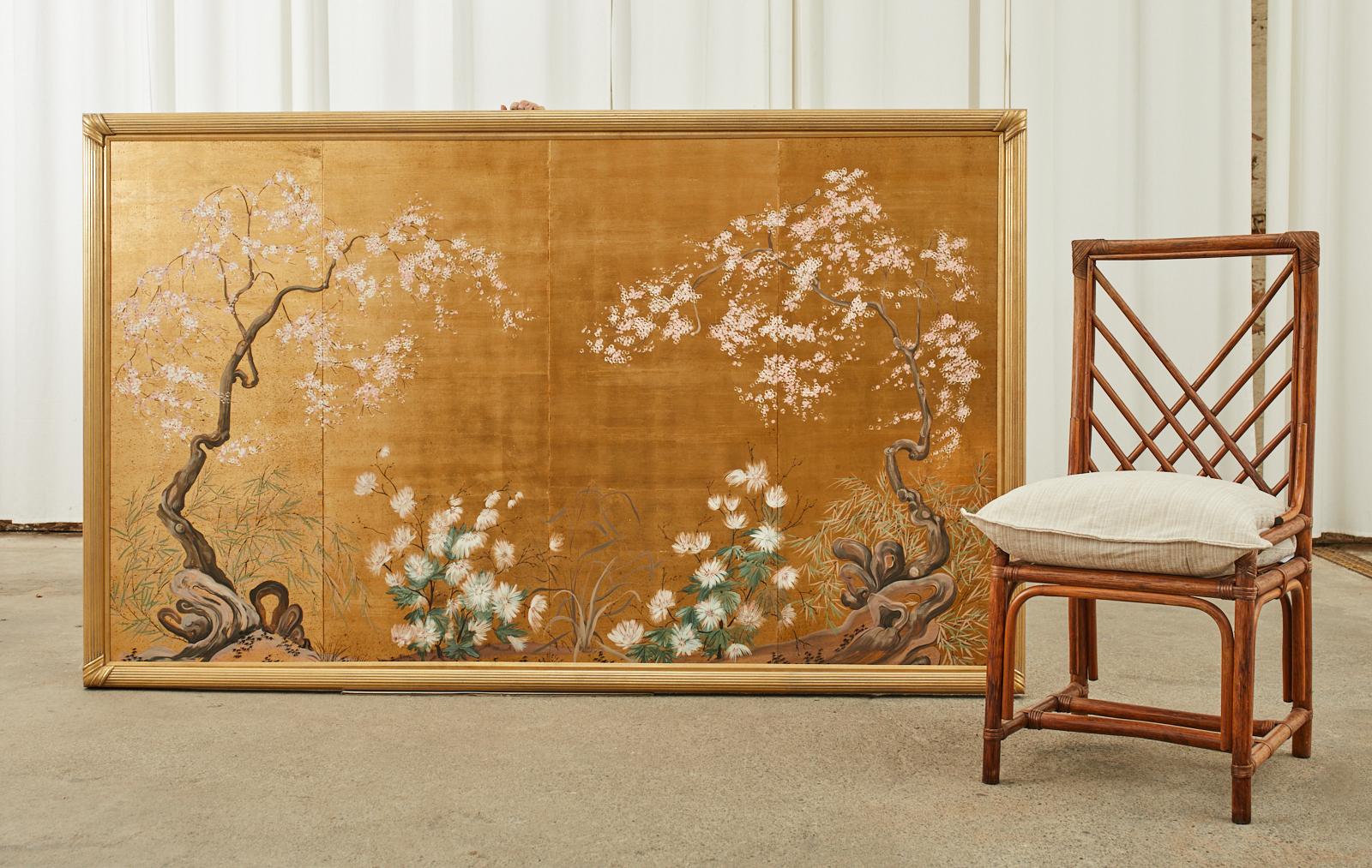Amazing four panel screen mounted in an opulent gilt, reeded frame depicting a spring floral landscape with cherry blossoms. Made in the Japanese Meiji period style in the manner of Robert Crowder and Gracie. Ink and natural pigments on a dramatic
