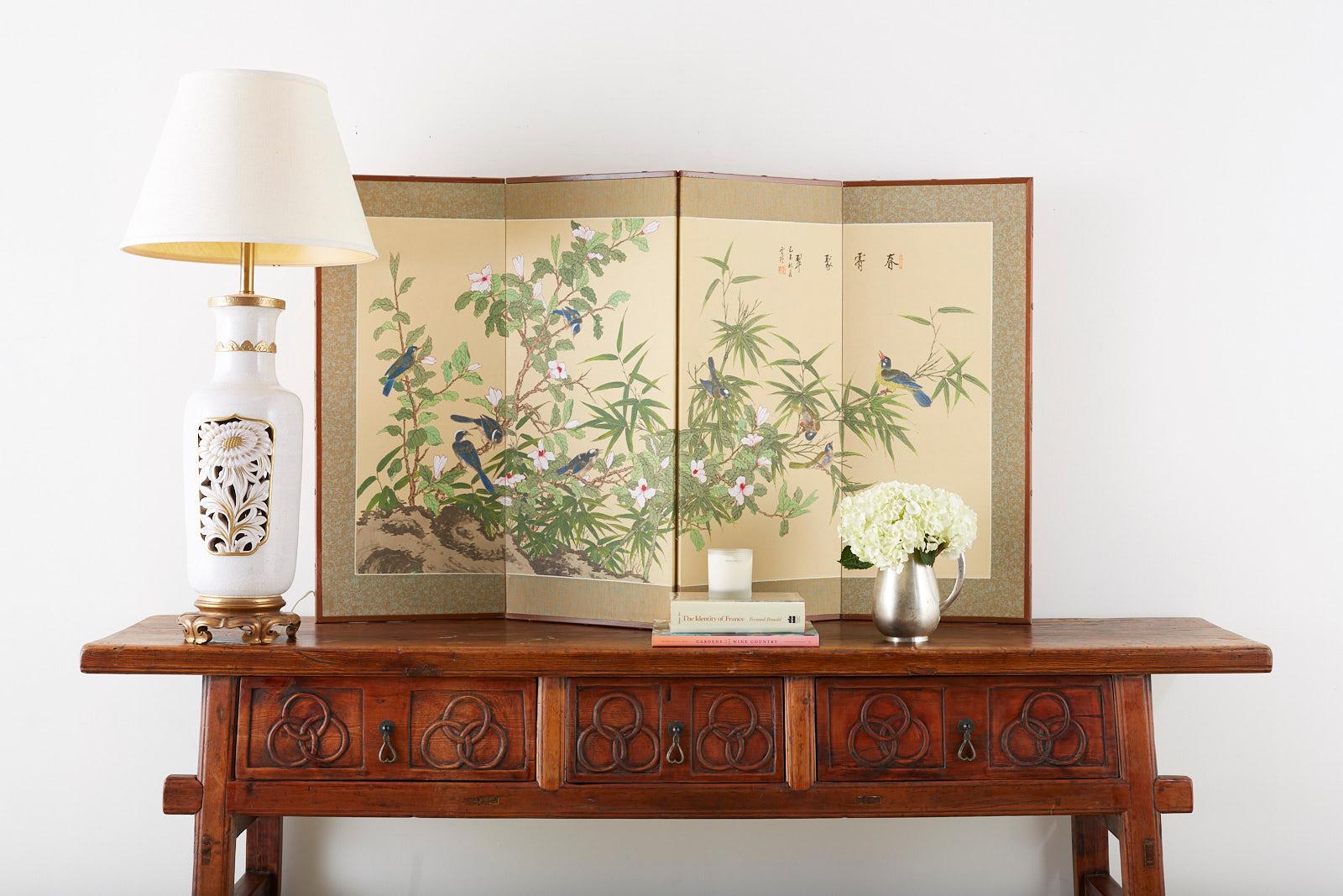 Gorgeous Japanese byobu style silk four-panel screen of flora and fauna. Vibrant spring green foliage and white flowers amid several indigo blue song birds. Signed and sealed on top right by artist Yuye with a cyclical date ji-wei autumn 1979 and