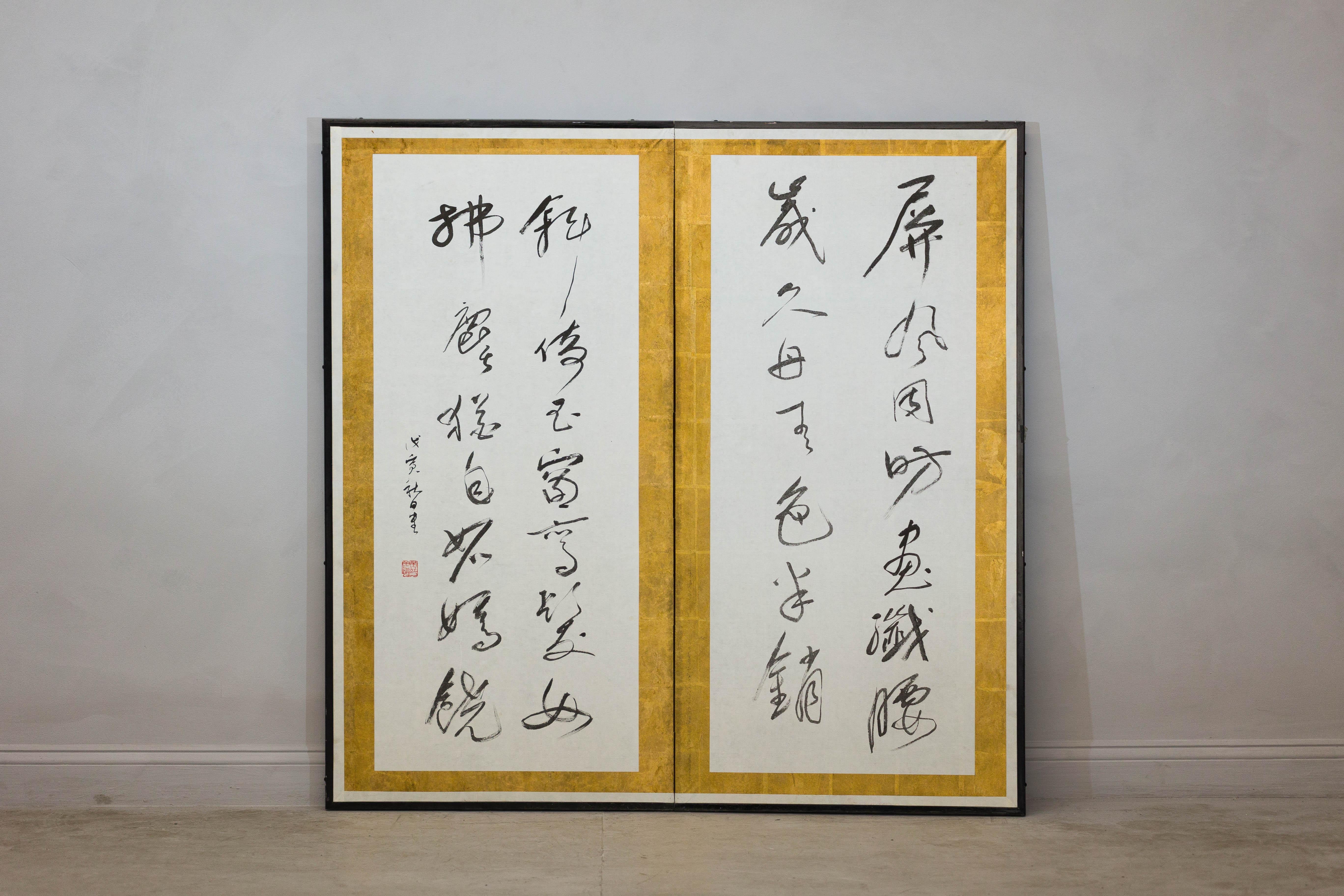 Paravento giapponese con calligrafia dipinta a mano e sigillo rosso del produttore. Questo sorprendente paravento a due pannelli è una magistrale rappresentazione dello shodō, l'arte giapponese della calligrafia. Pennellate audaci e fluide