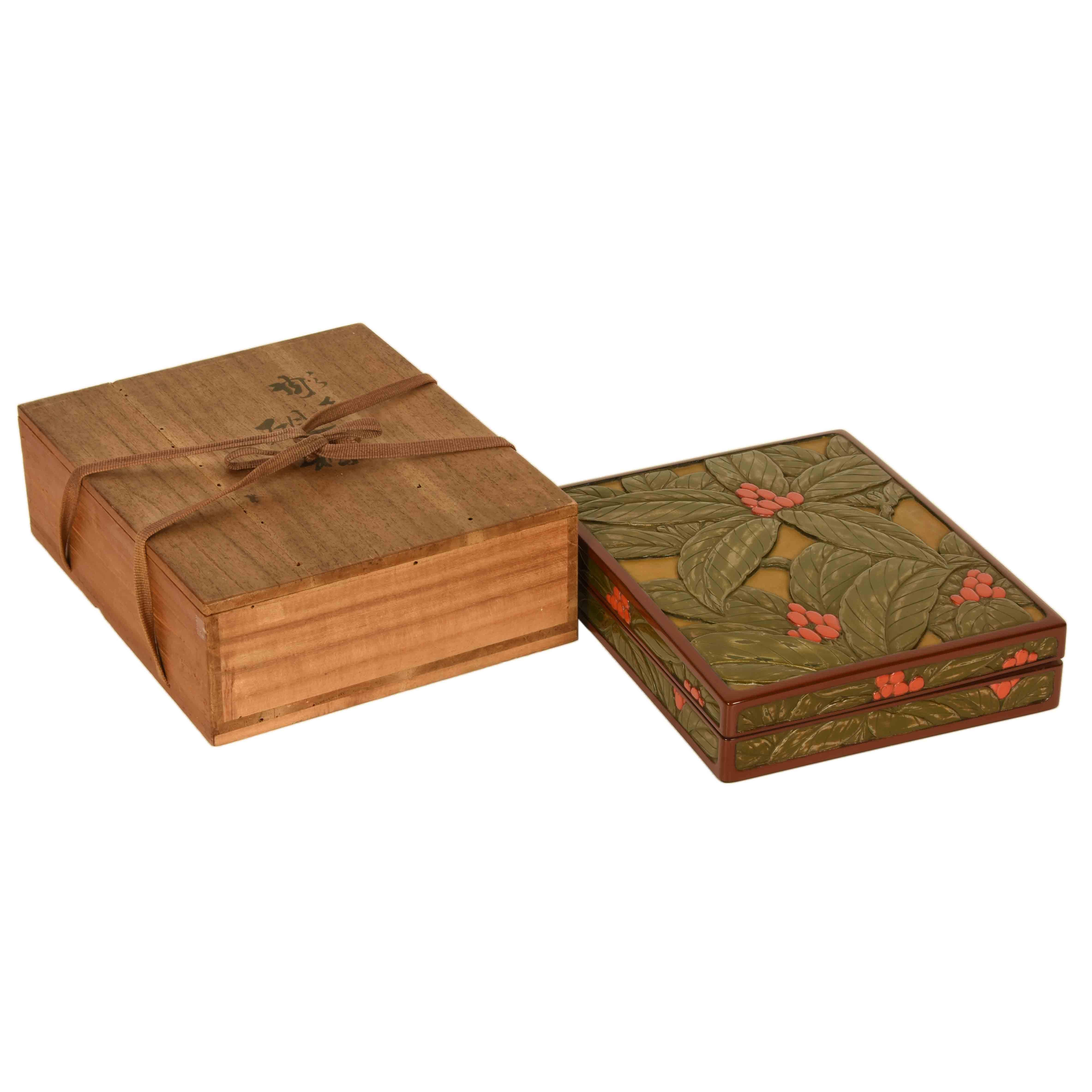 A vintage Japanese Tsuzuri bako, writing box. with an unusual, deeply carved relief of Japanese sarcandra glabra, a woody herbal sub-shrub native to Asia with deep green glossy leaves and red berry like fruit. Kamakura lacquerware is primarily made