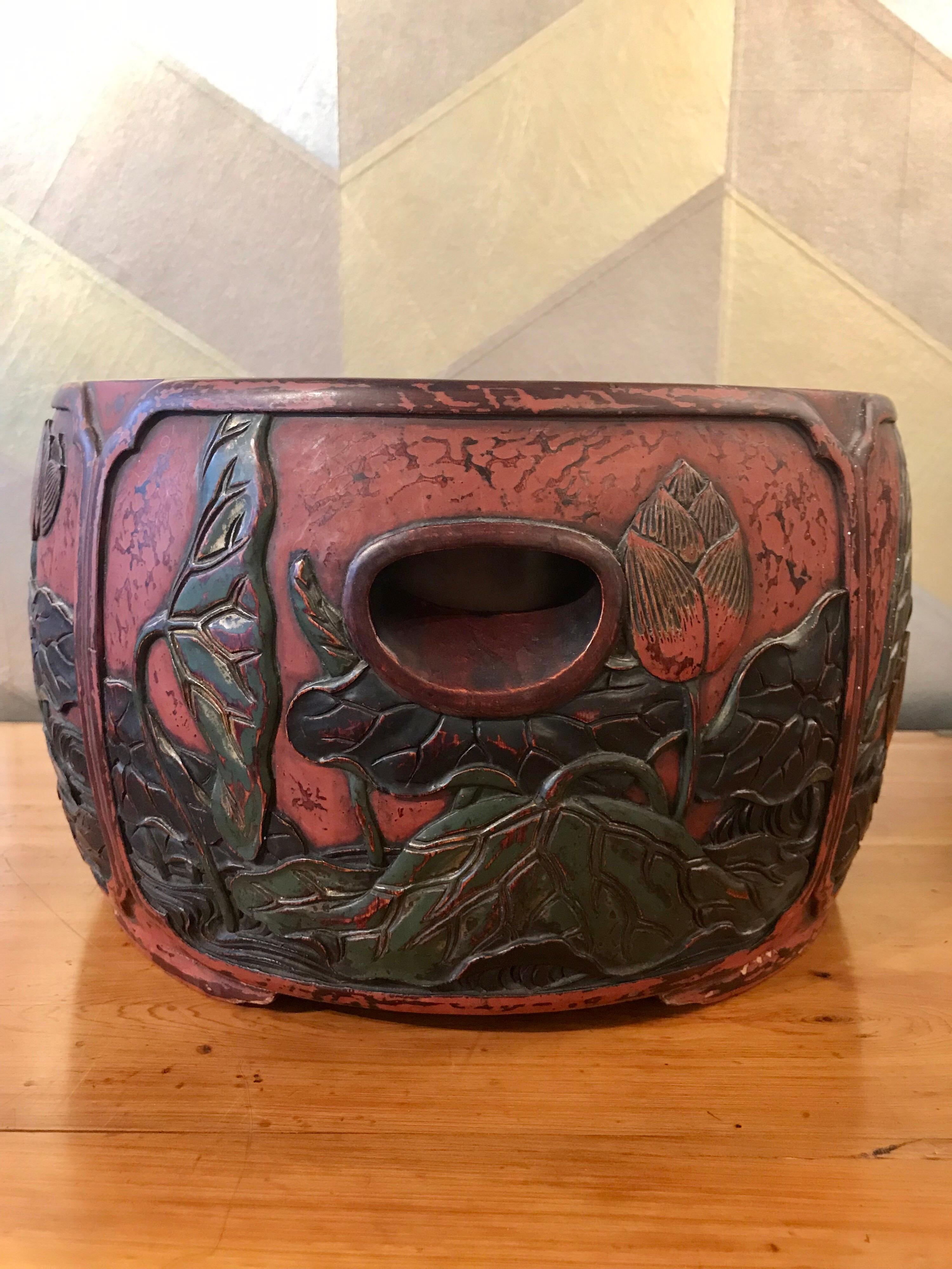 An exquisite deeply carved red lacquer hibachi (I use them at home for my orchids!) with panels of floral design.

There is a copper liner, and it stands on four feet.

There are four large reserves with design. The water is in black lacquer,