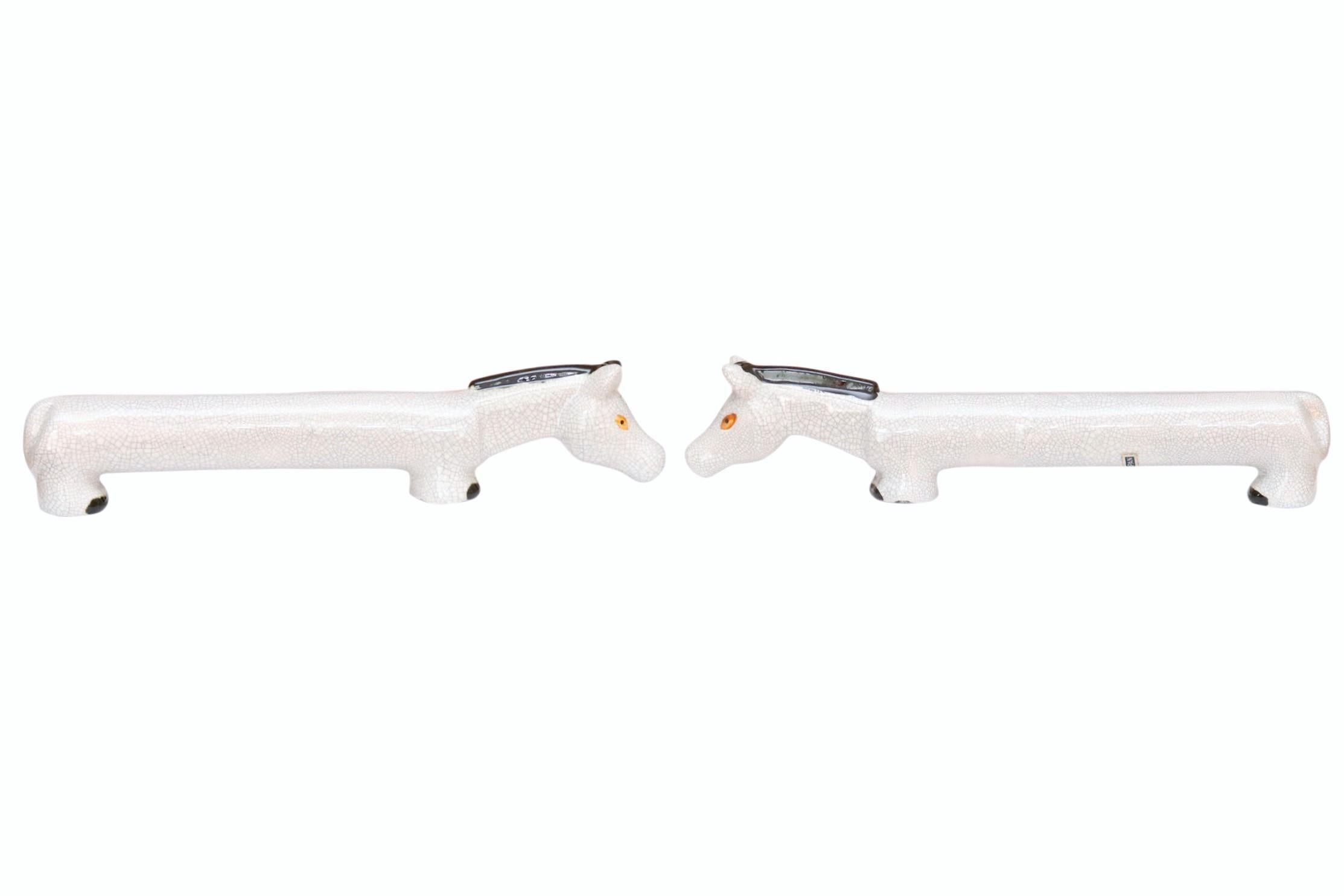 Un set di sali e pepiere per cavalli. I cavalli grigi hanno il dorso allungato e la testa lunga e protesa in avanti. Decorato con occhi gialli, teste e zoccoli neri con una finitura craquelure su tutta la superficie. I fori nei piedini consentono di