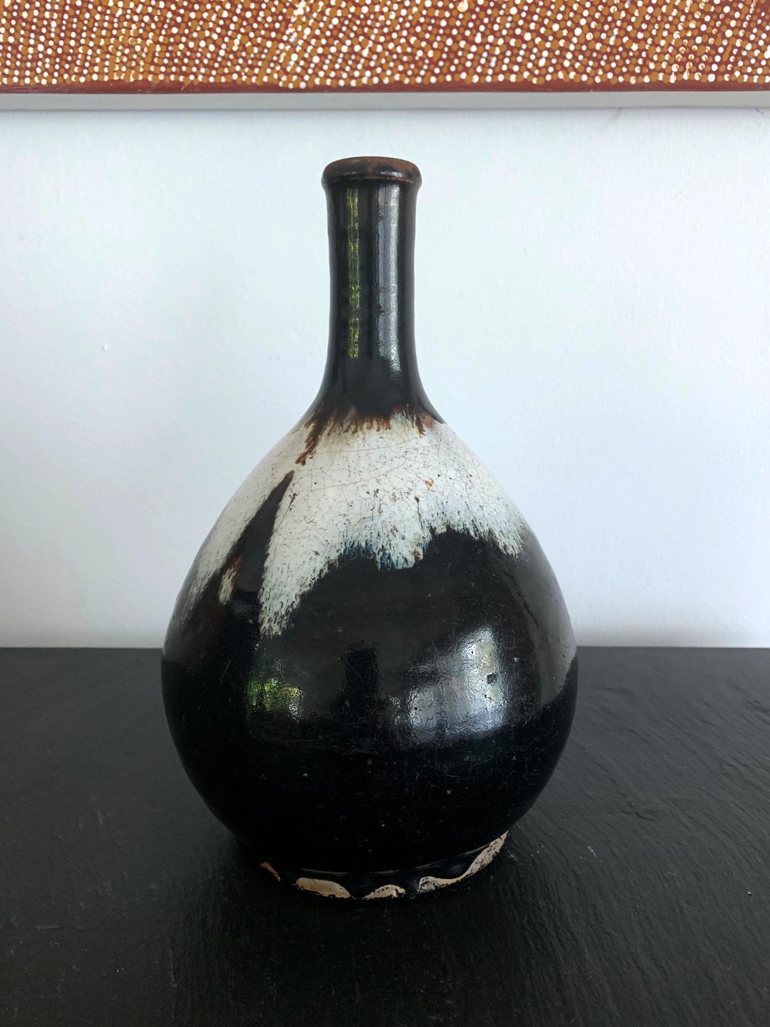 The long neck bottle of classic form was heavily potted with coarse clay with high iron content. The flask, circa 18th century Edo period, was purposed for sake storage but also substituted as a flower vase during tea ceremony. The surface is