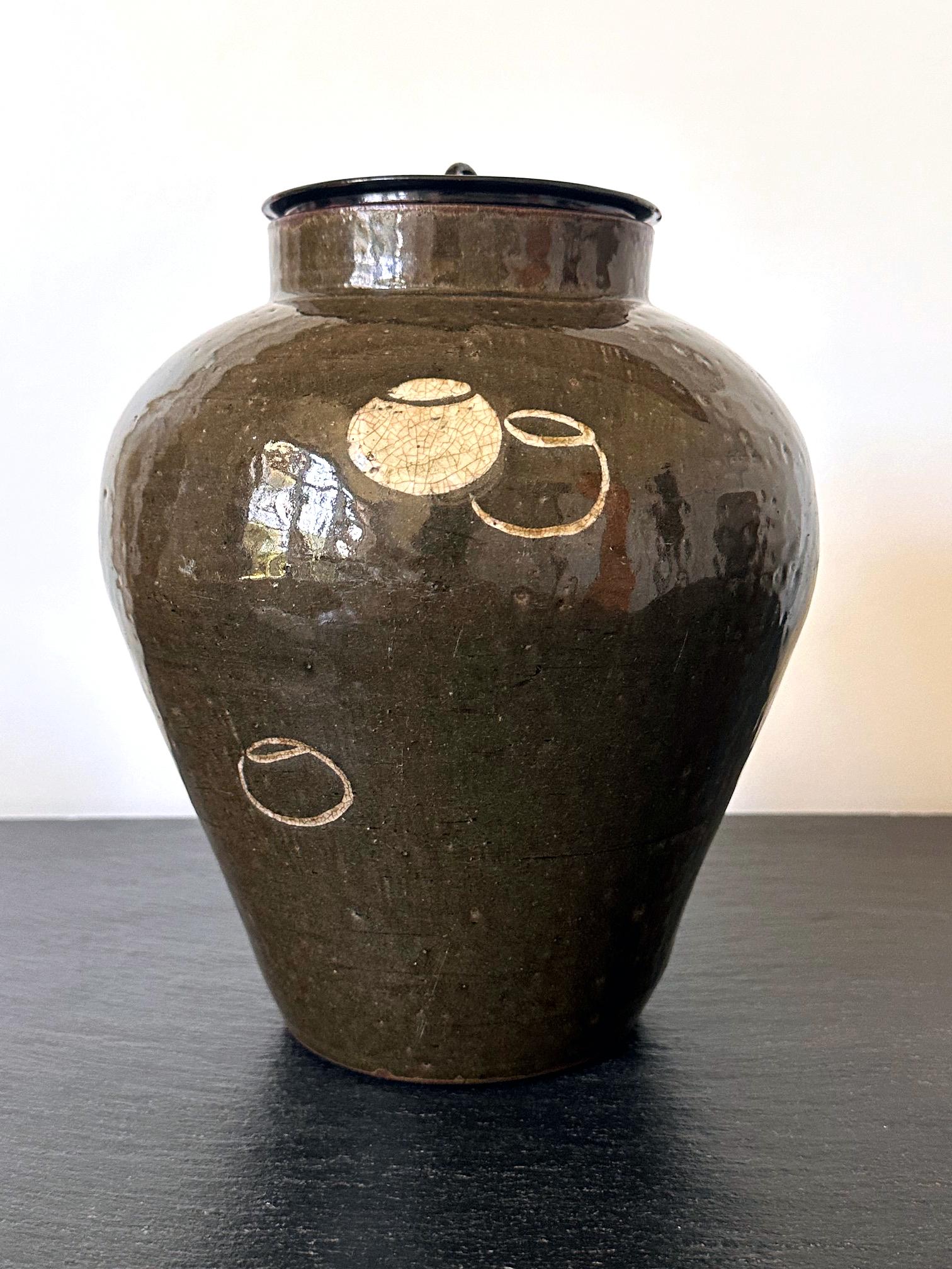 A Japanese glazed ceramic jar with a lacquered wood lid circa 19th century of late Edo to early Meiji Period. The stoneware tsubo was used as a storage vessel for produce such as tea leaves. It was made in Seto, one of the six ancient kilns in