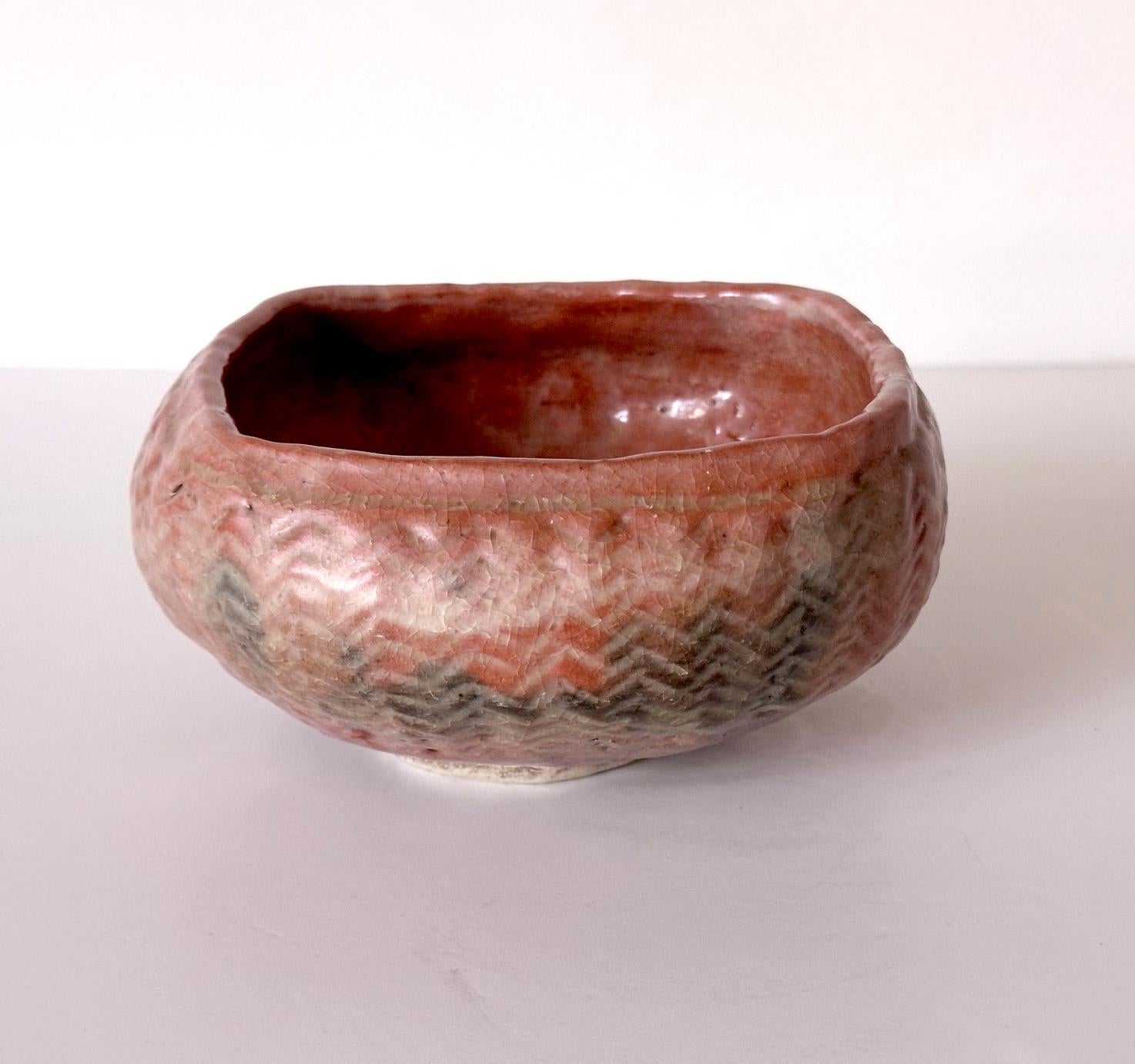 An unusually shaped ceramic chawan made by Kodai-ji Kiln in Kyoto circa 19th century of Meiji Period. The bowl has a rounded shape of a monk's alms bowl supported by a short foot ring, but it has a square mouth opening. The exterior features carved