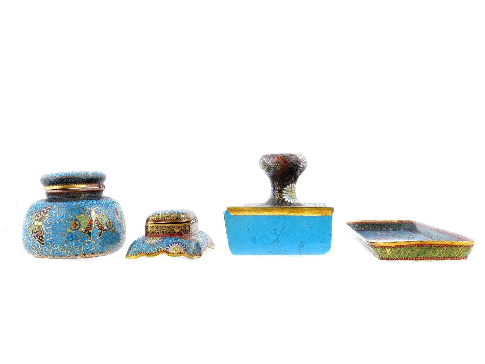 Un set da scrivania giapponese di quattro pezzi con decorazioni in smalto cloisonne policromo. Il set comprende una coppia di calamai, un blotter a rullo e un vassoio. Ogni oggetto è ornato da un disegno policromo raffigurante farfalle e fiori